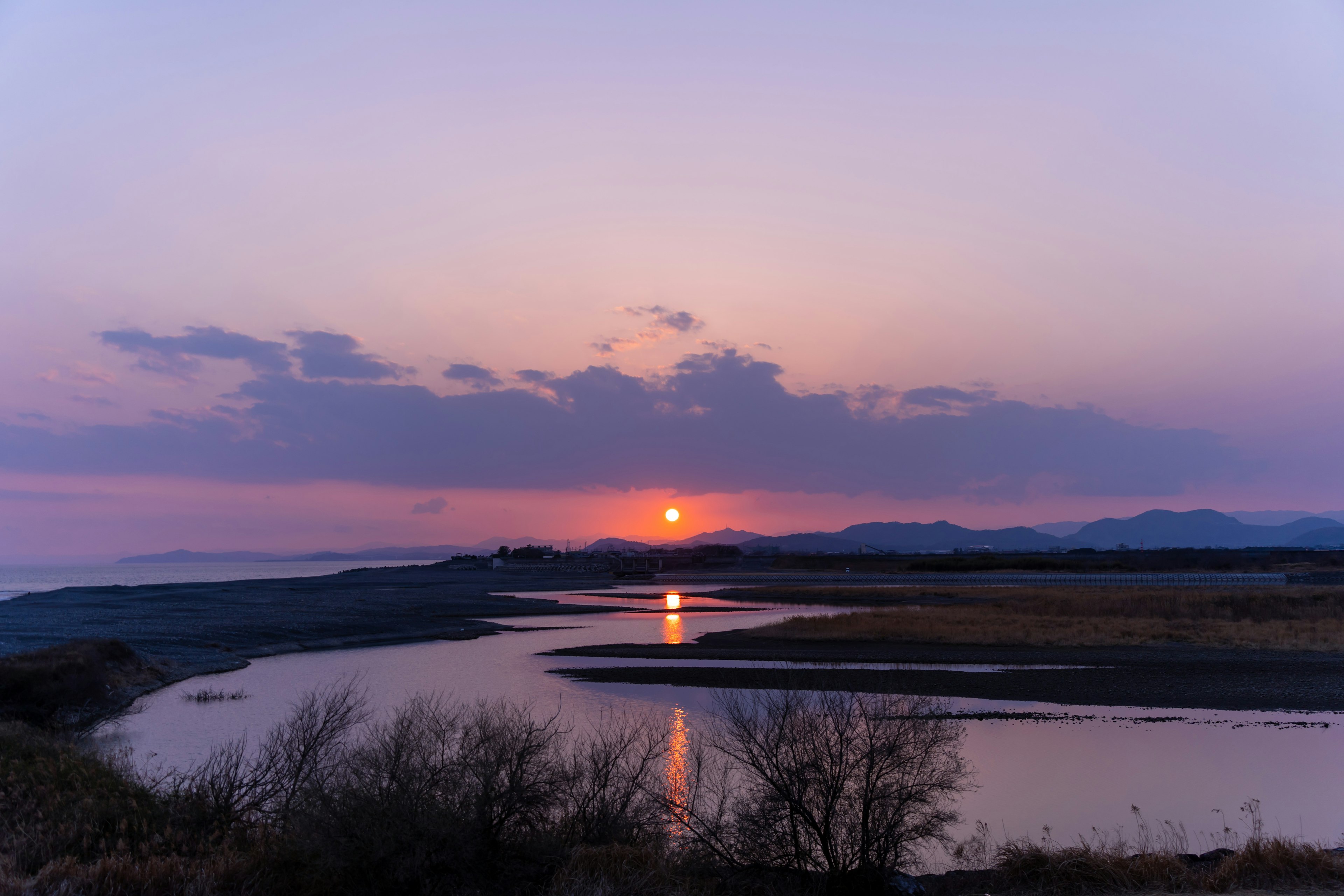 夕日が海に沈む美しい風景と静かな川の反射