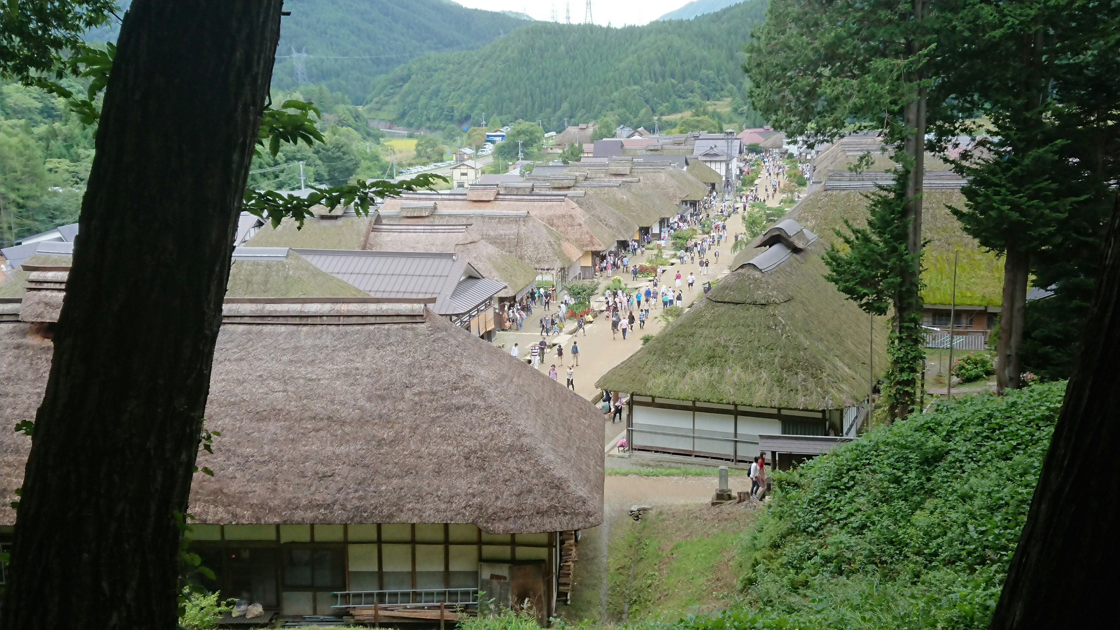 Pemandangan desa Jepang tradisional di pegunungan dengan rumah atap rumbia