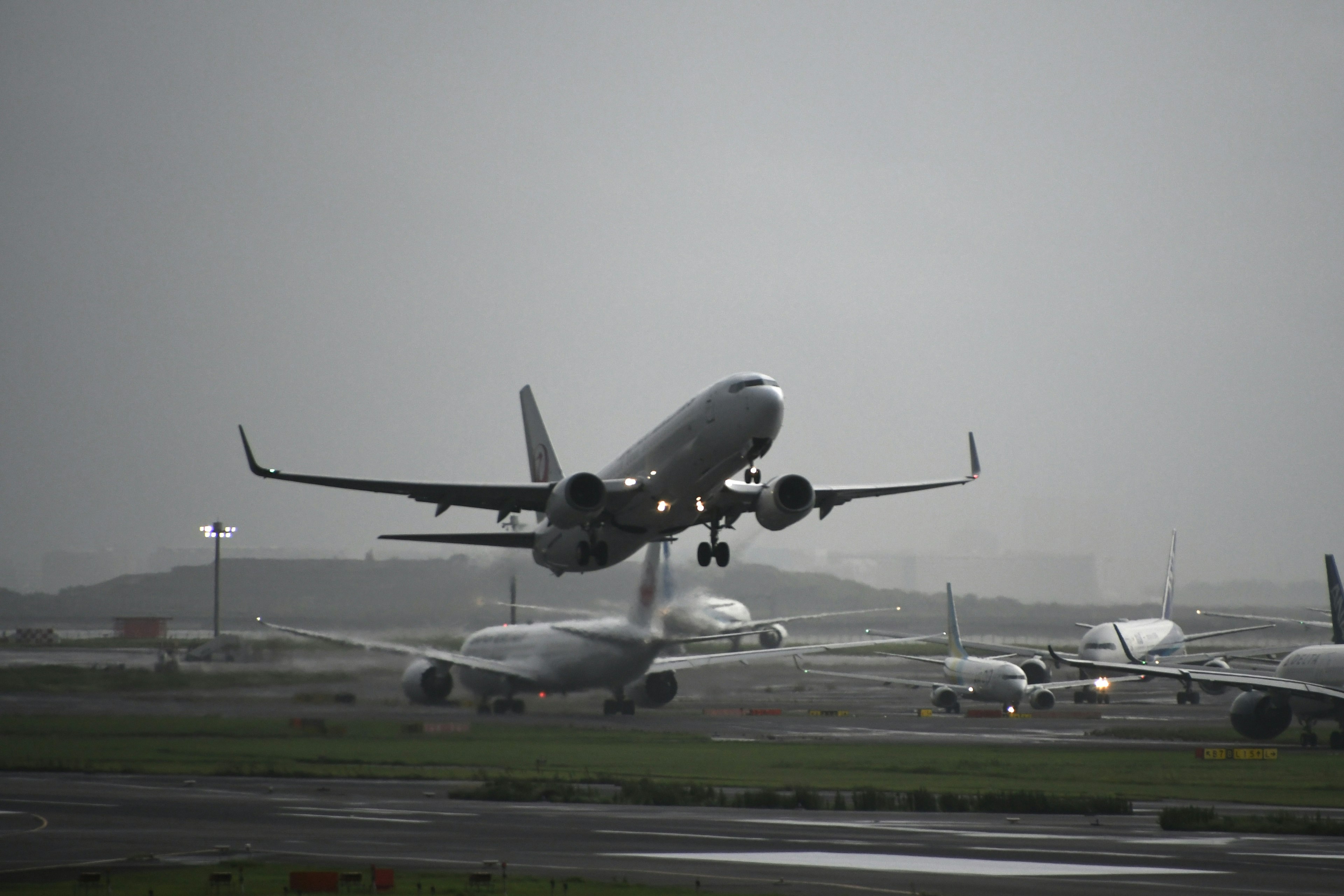 Ein Flugzeug, das unter bewölktem Himmel von einem Flughafen abhebt