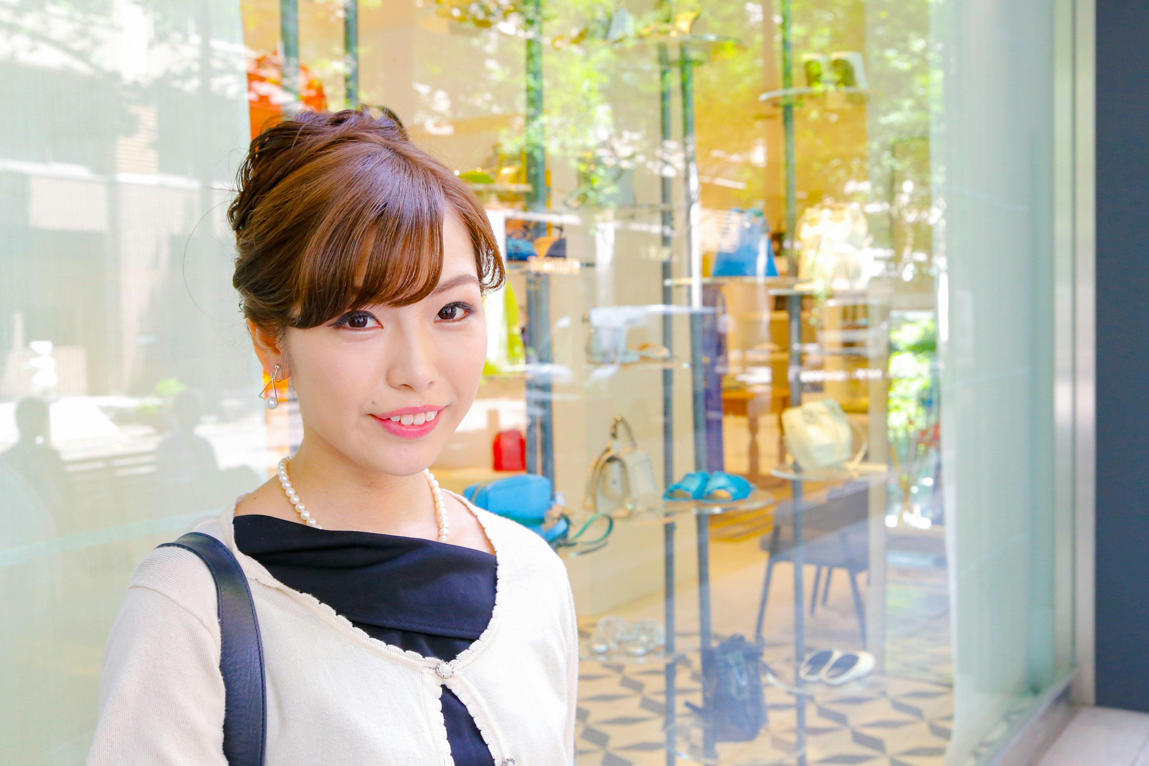 Femme souriante en tenue élégante devant une vitrine lumineuse