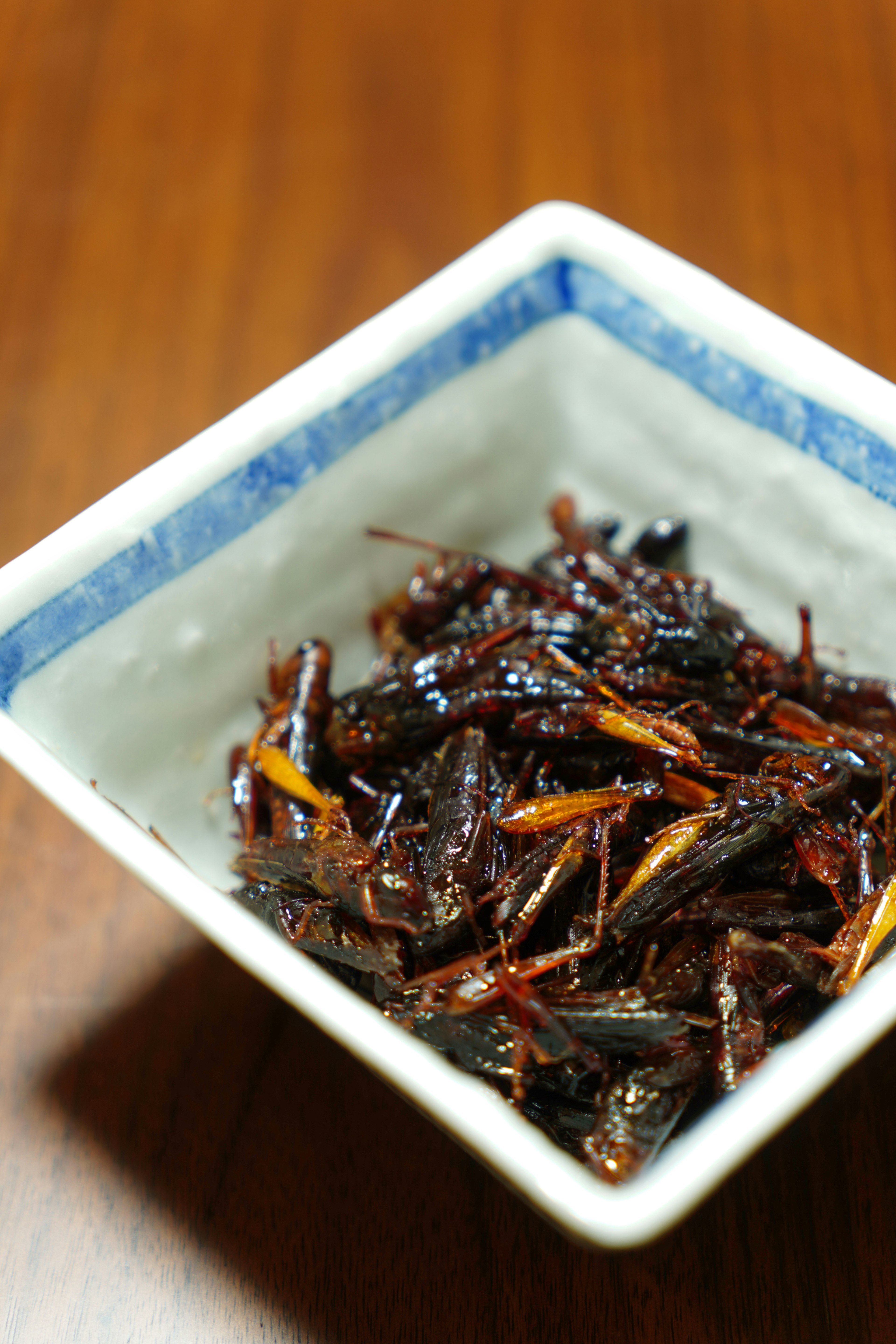 A small bowl filled with sweet and savory dried fish delicacy