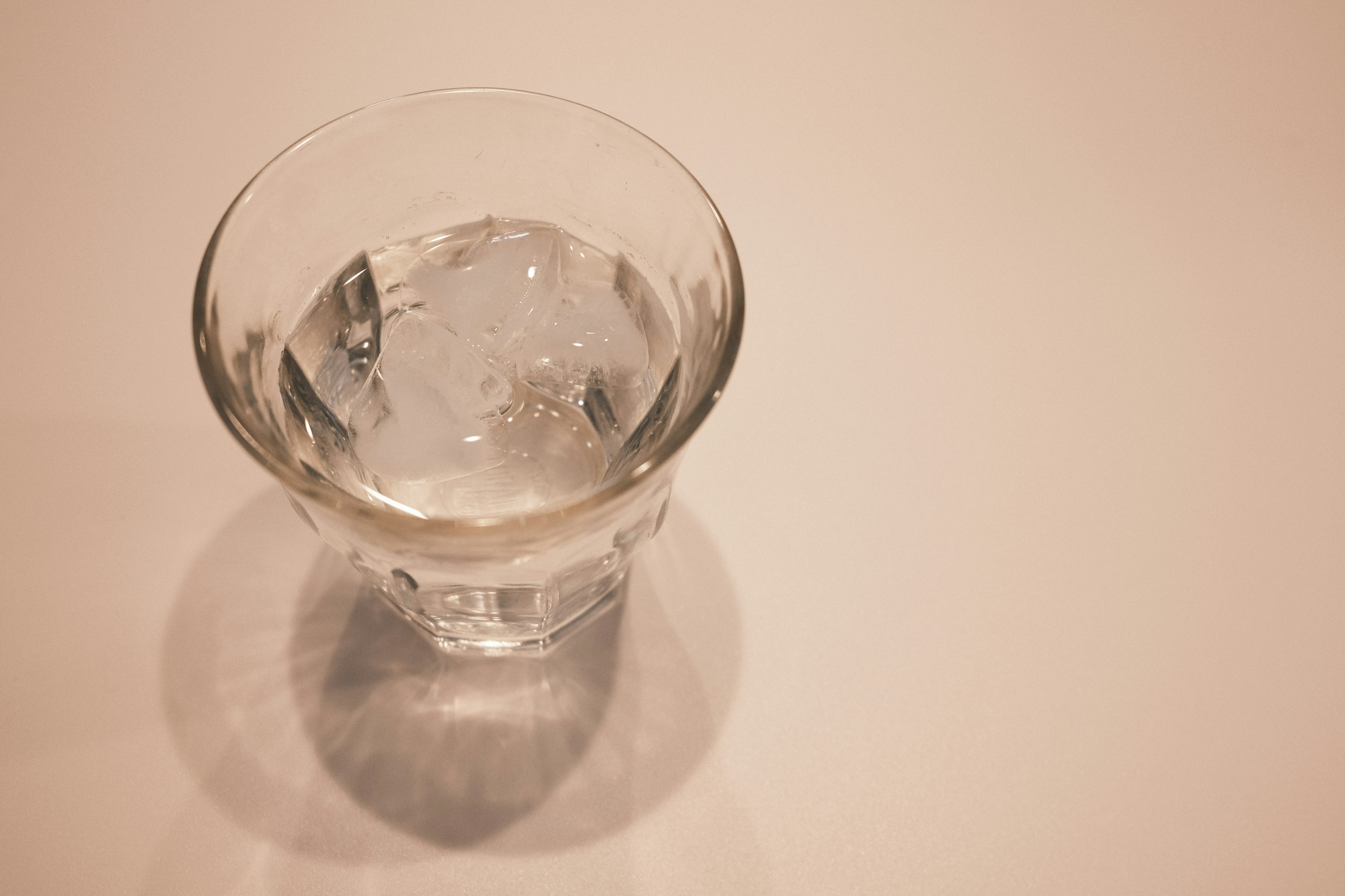 A clear glass filled with water on a light background