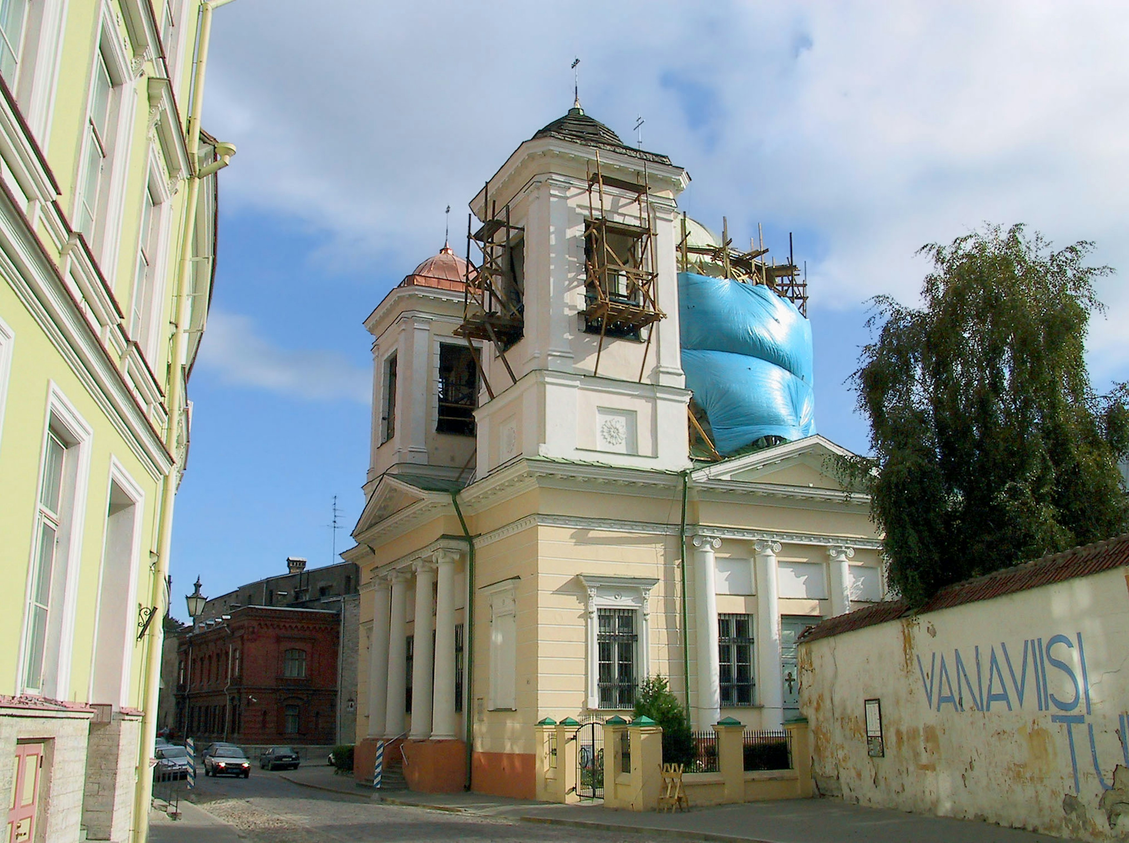 Chiesa in ristrutturazione con impalcature e telo blu