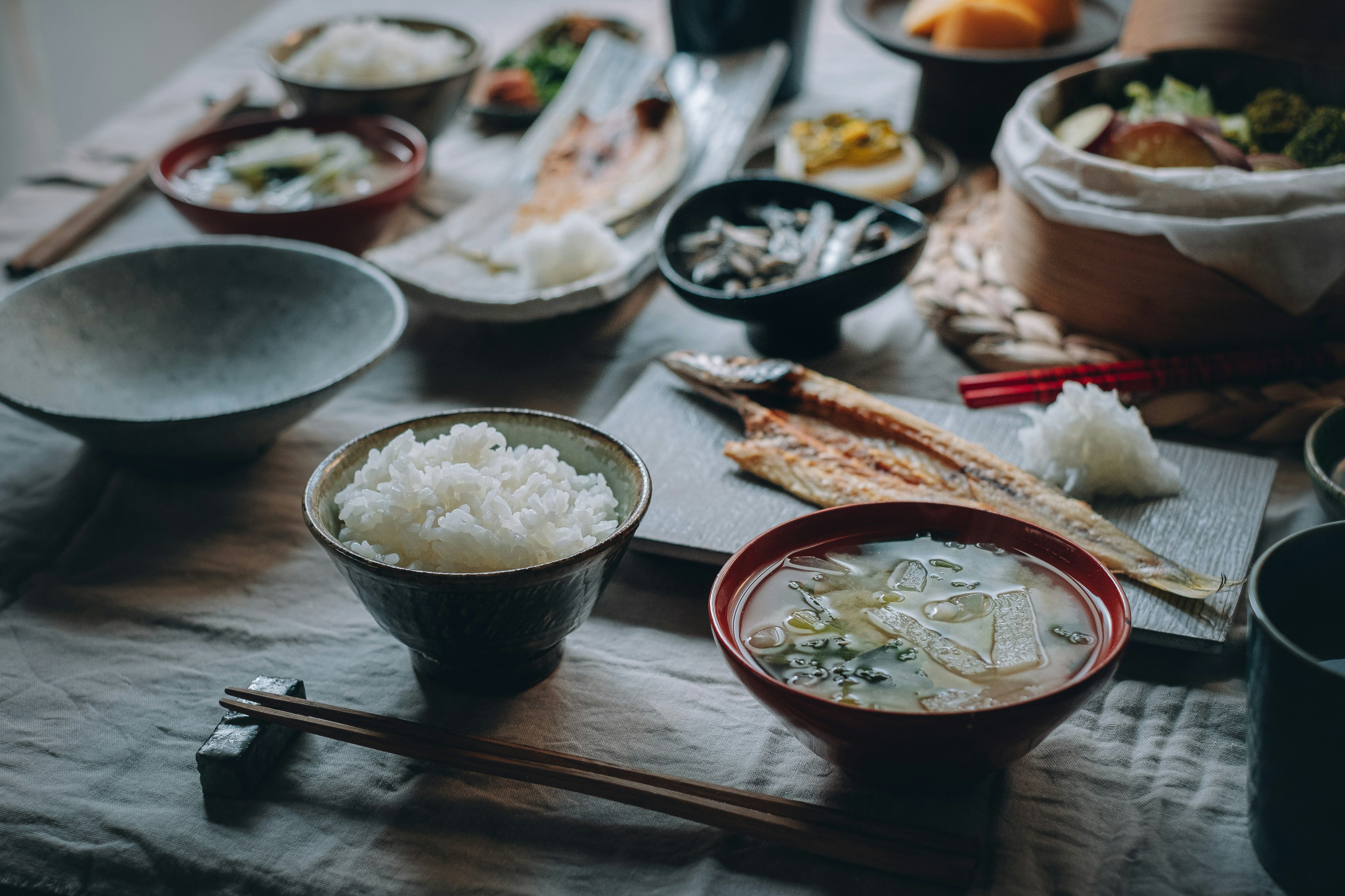 Ein Tisch mit einer Vielzahl japanischer Gerichte, darunter Reis und Miso-Suppe