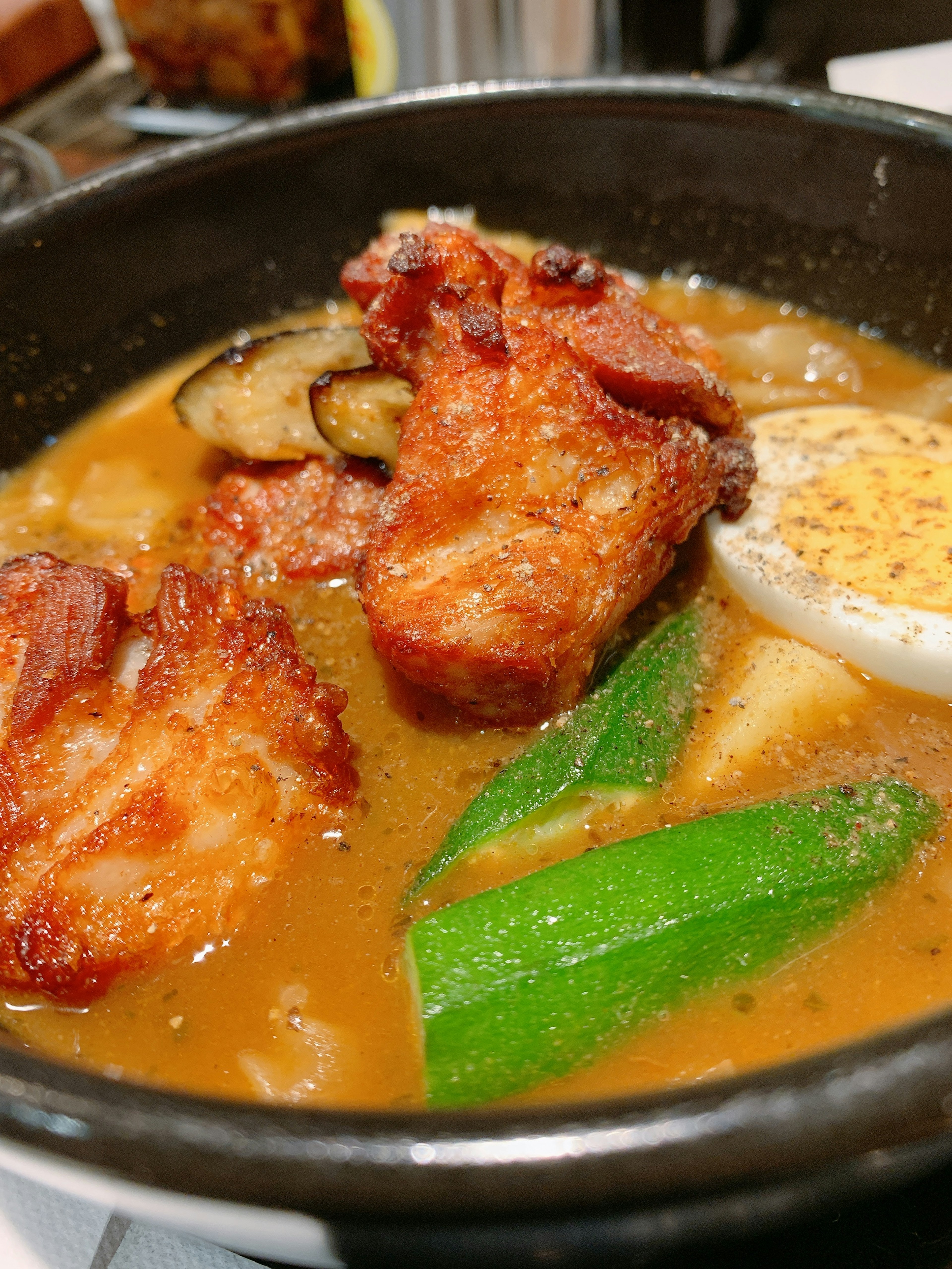 Curry delizioso in una pentola con pollo fritto, verdure e un uovo