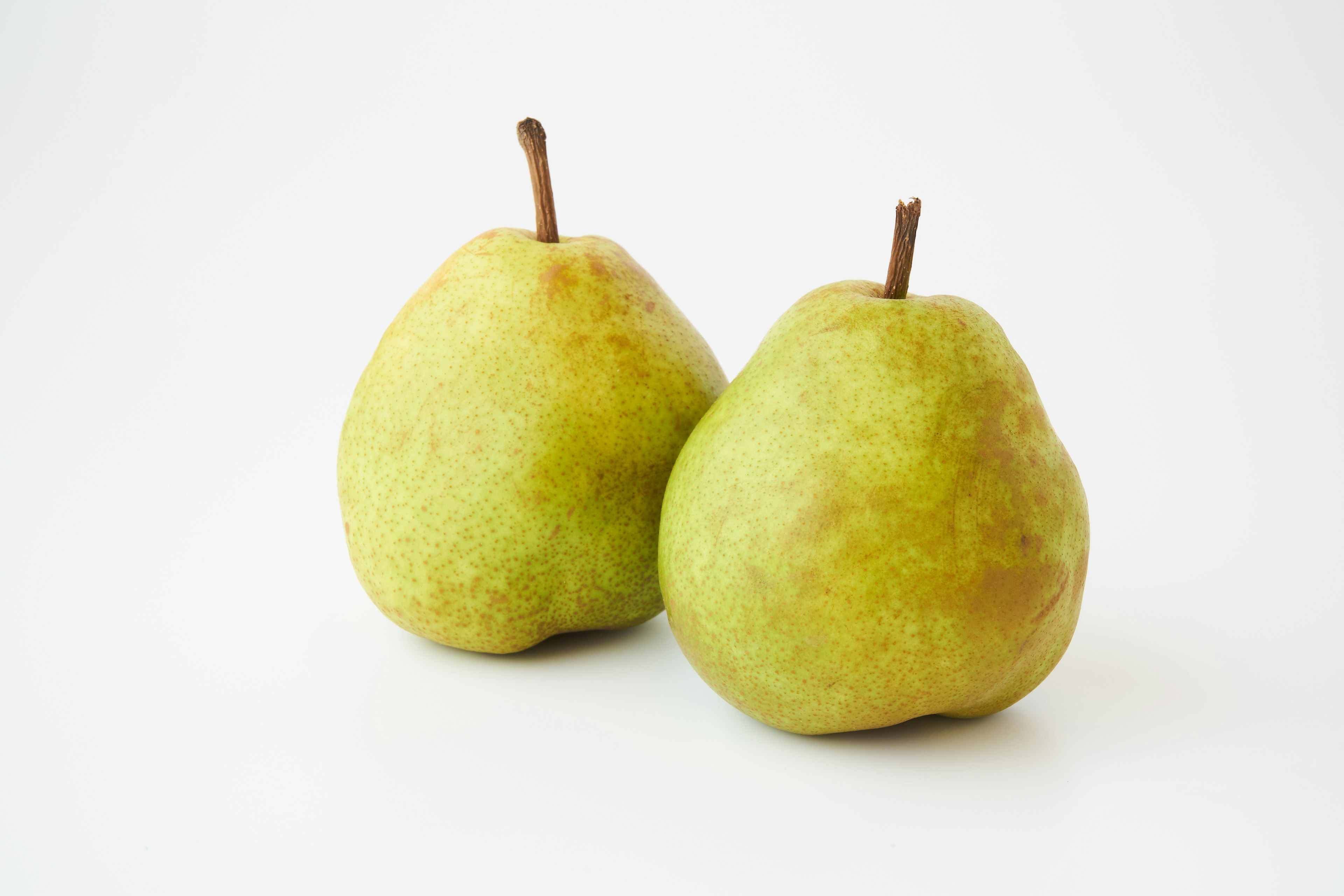 Two green pears on a simple white background