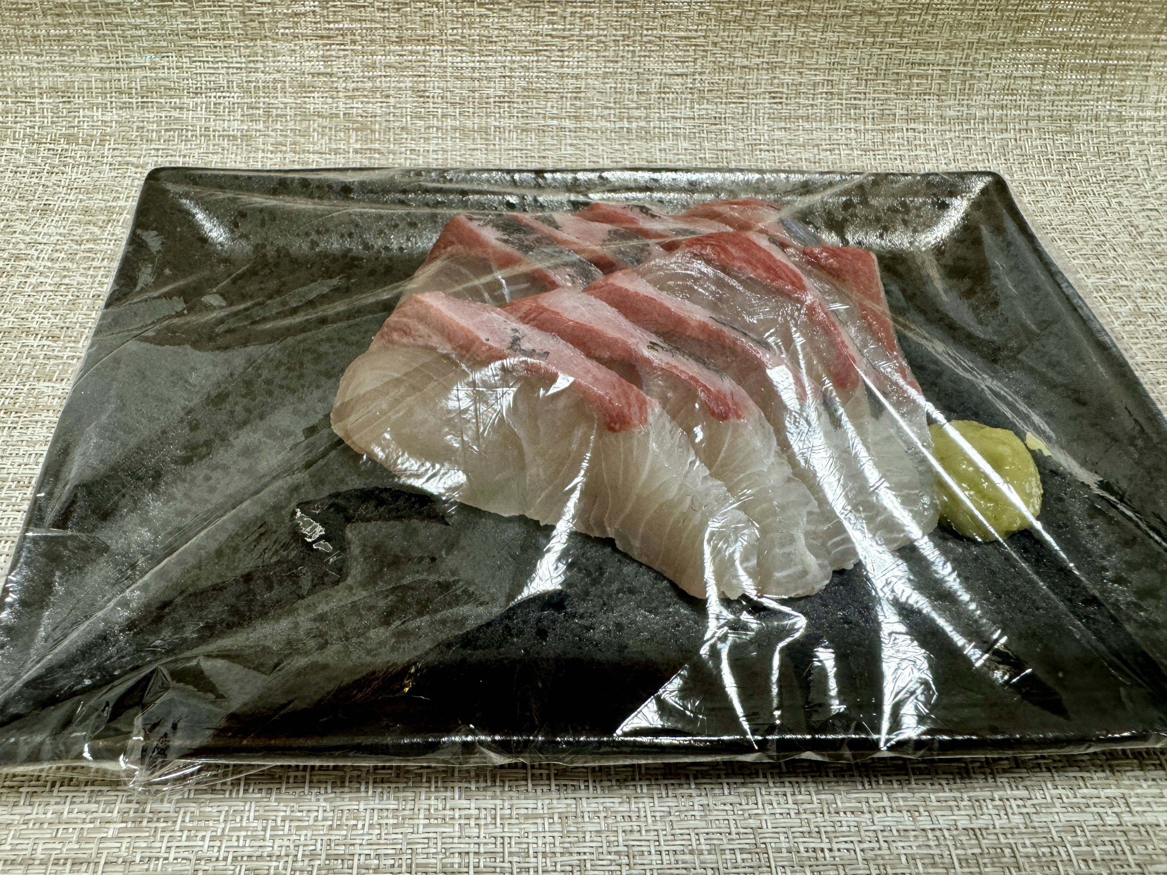 Fresh sashimi presentation wrapped in clear plastic