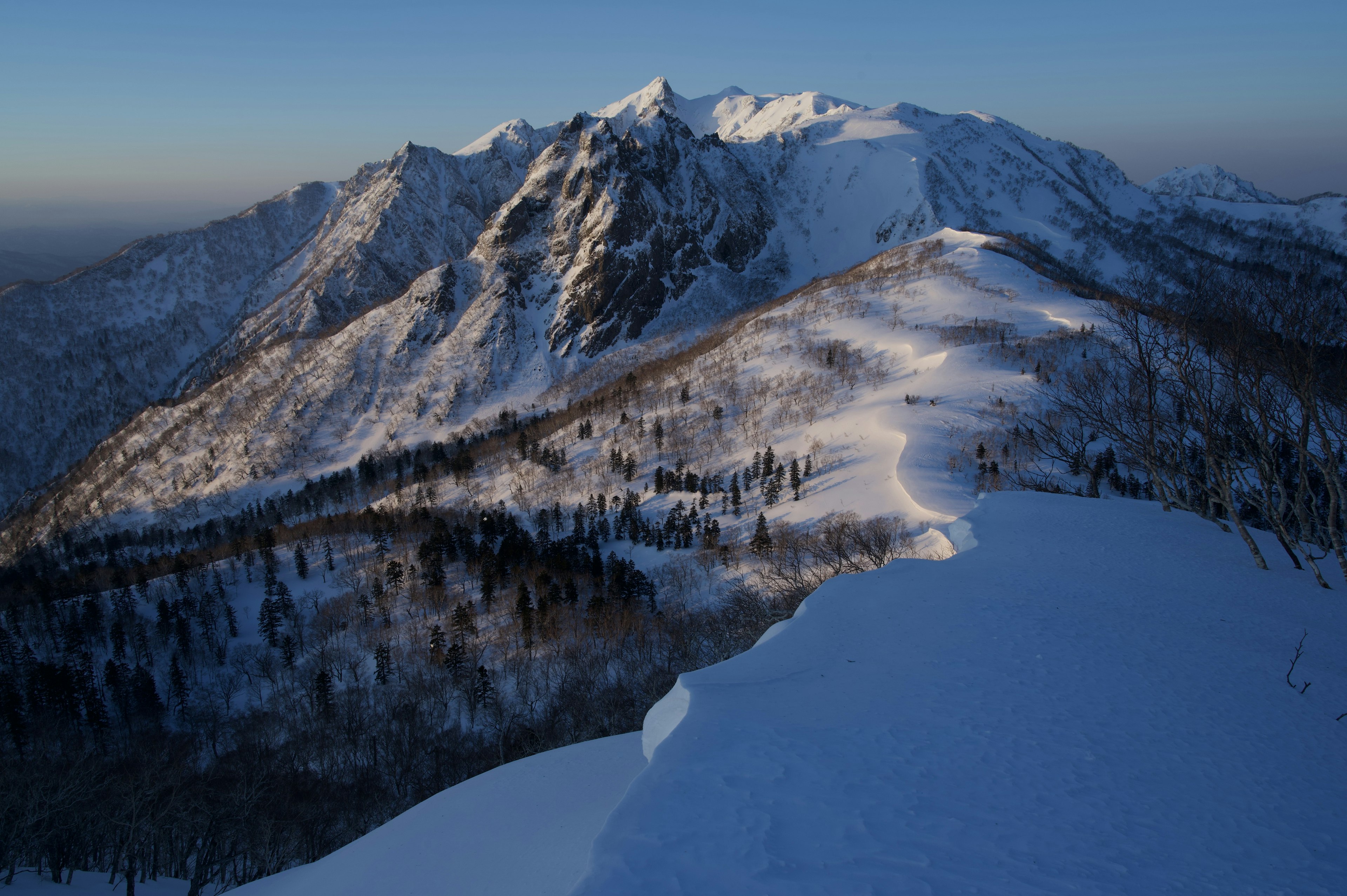 Snow-covered mountain landscape with a clear blue sky