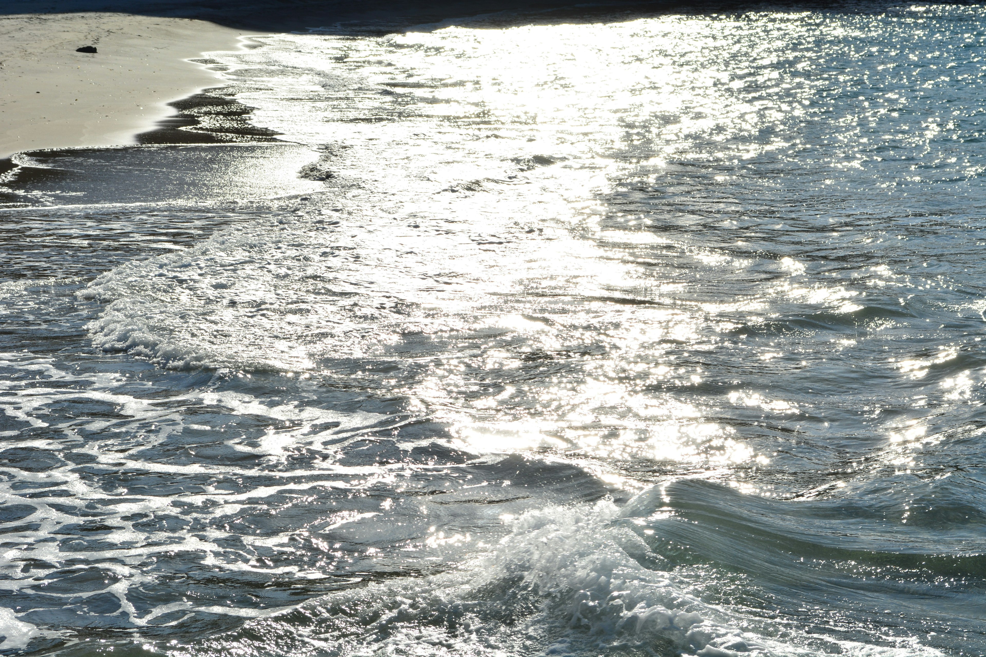 Vagues de l'océan réfléchissant la lumière du soleil sur le rivage