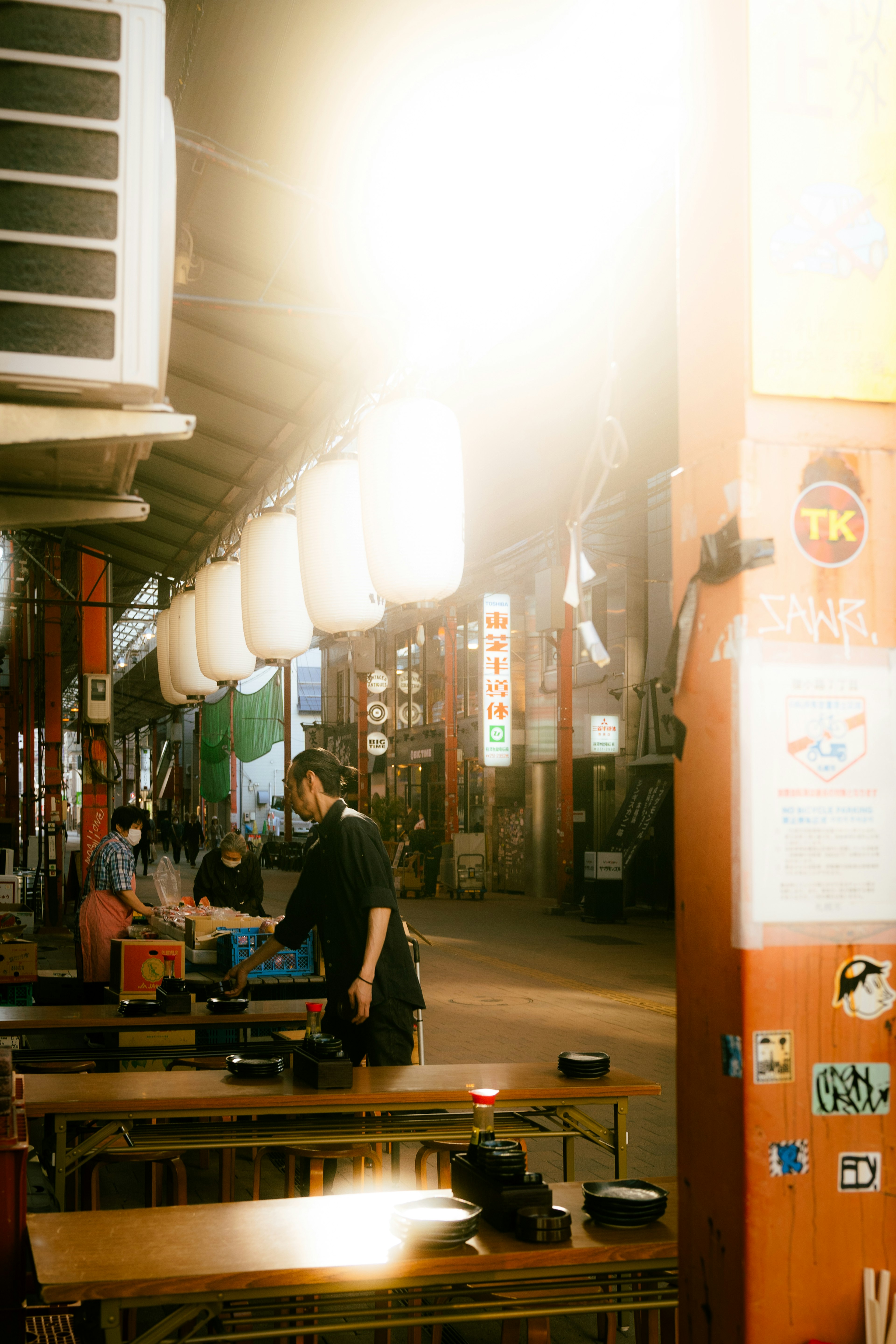 Scene of a market stall with people and bright lanterns