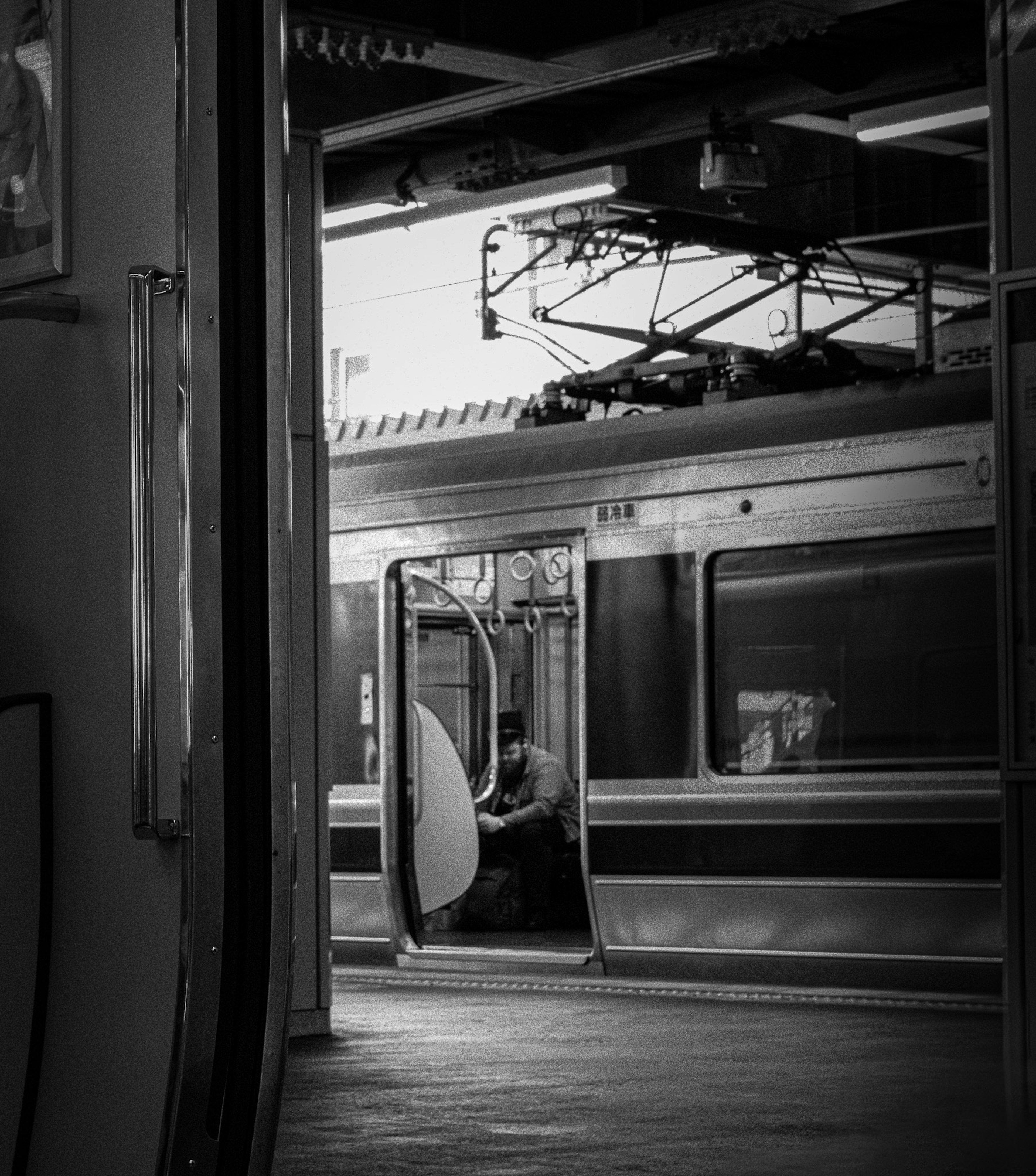 Foto en blanco y negro de una puerta de tren abierta en una plataforma