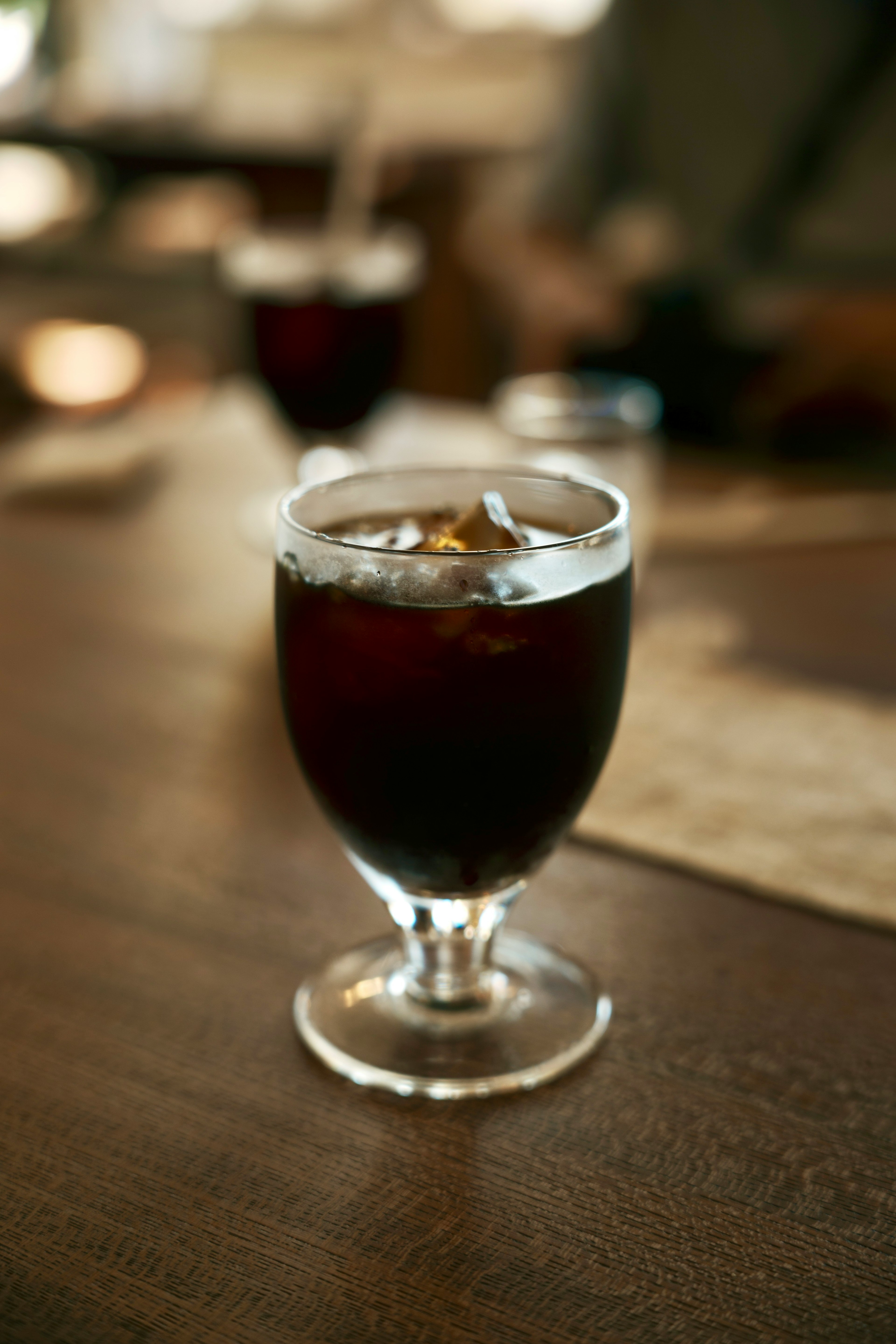 A glass of iced coffee on a wooden table