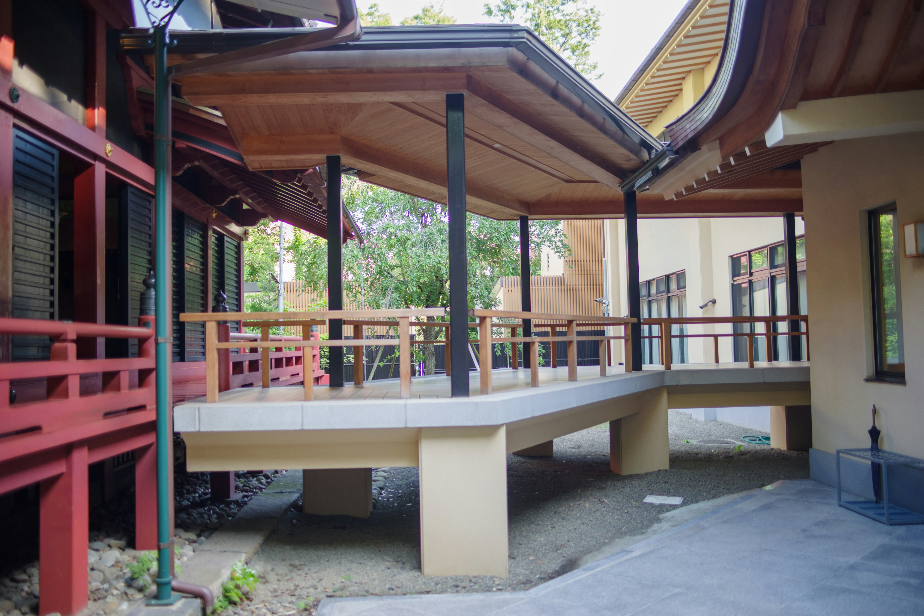 Japanese-style building with a wooden deck in a garden setting