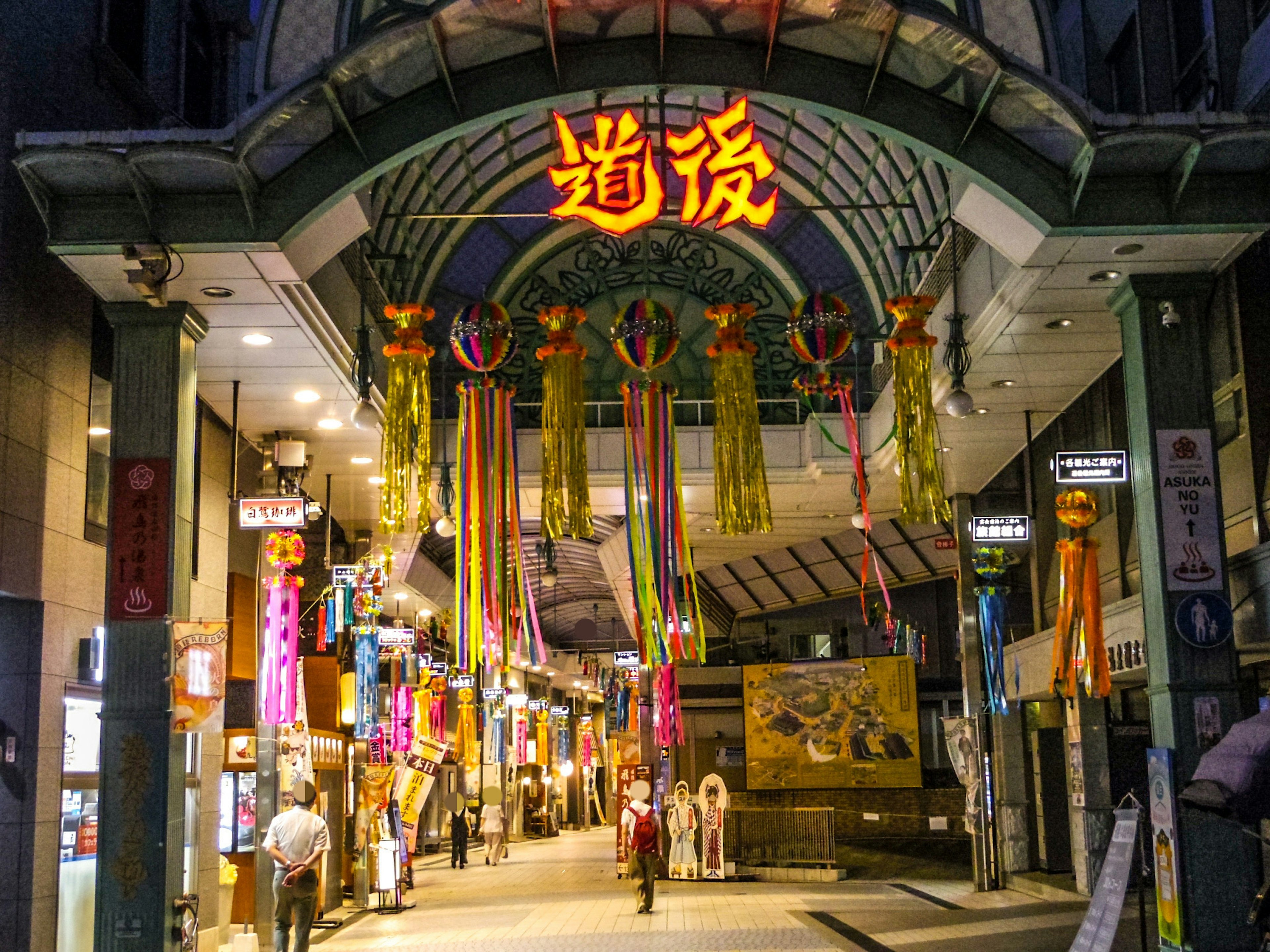 Arcade commerçante animée ornée de décorations colorées et de panneaux