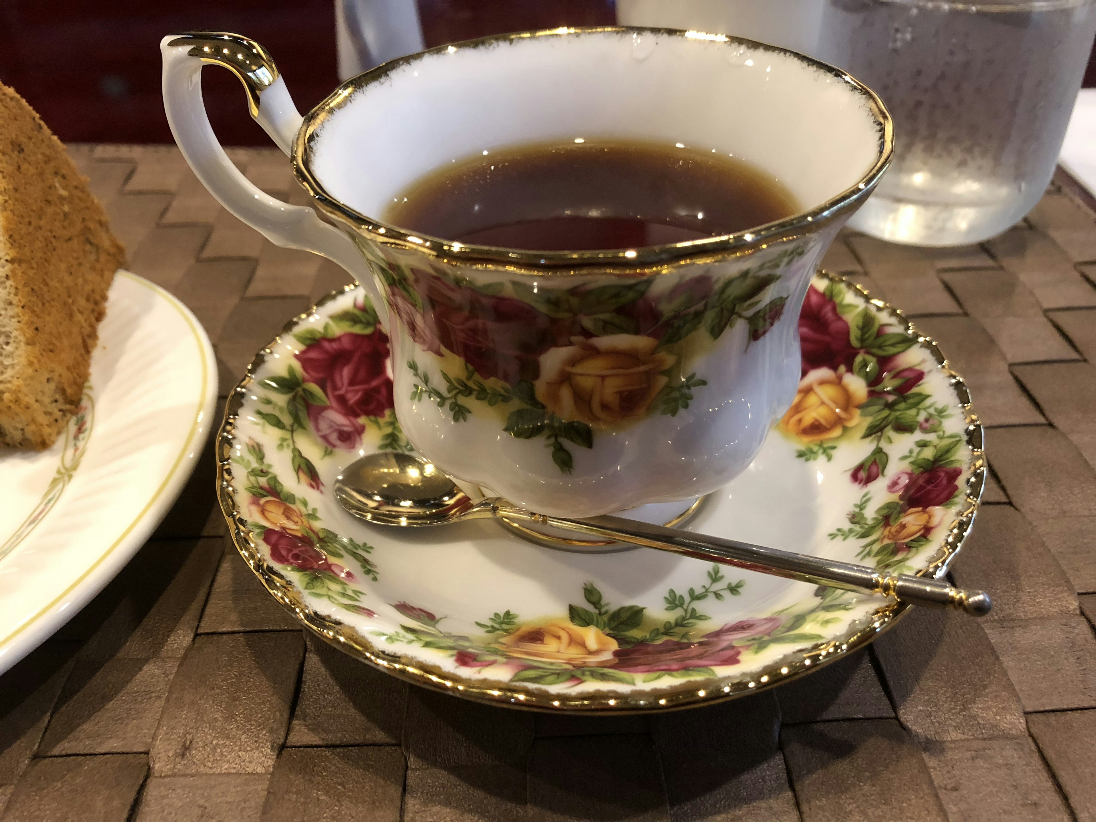 Tasse à thé et soucoupe à motifs floraux avec du thé