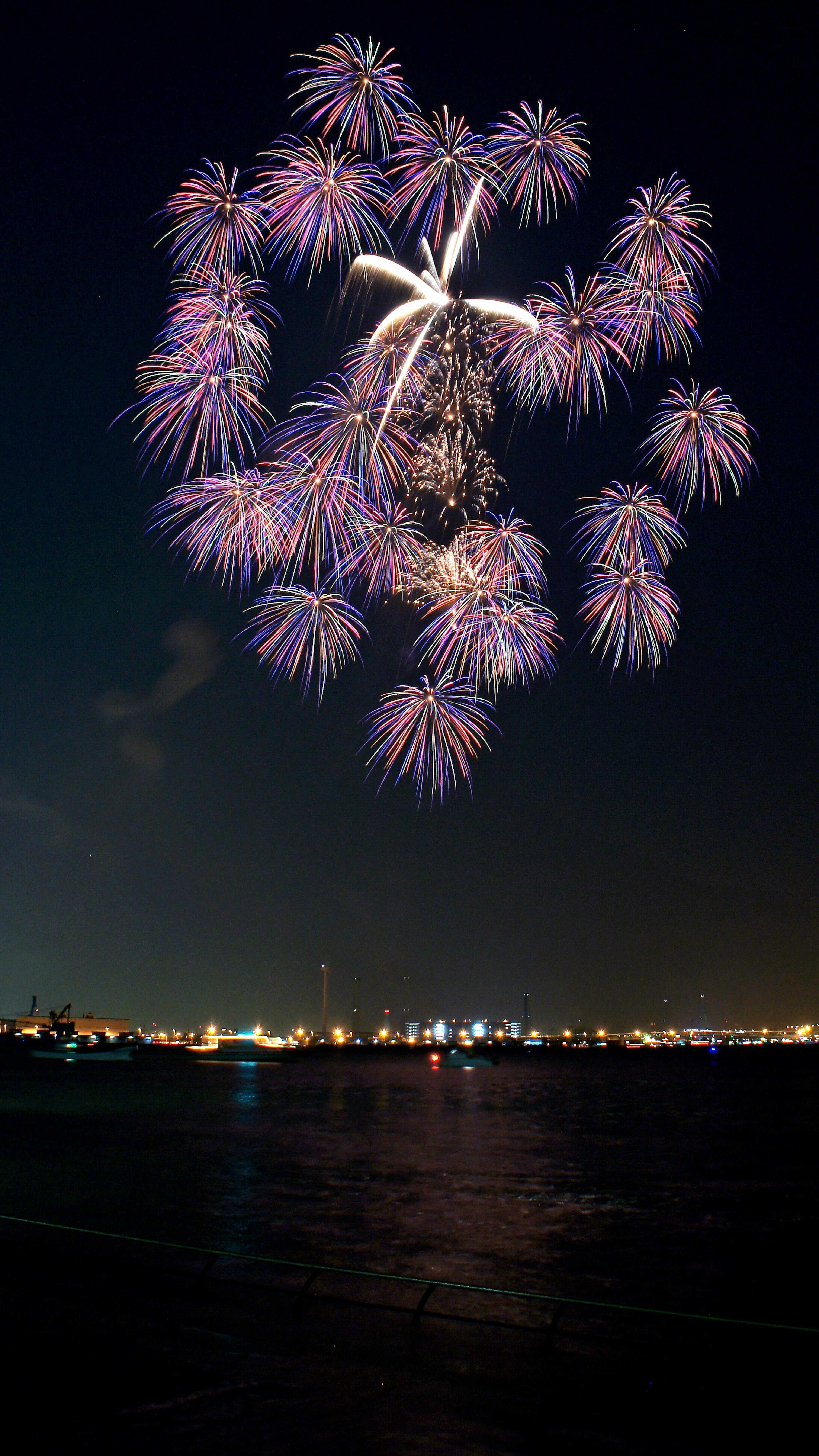 夜空中绚丽的烟花在水面上反射