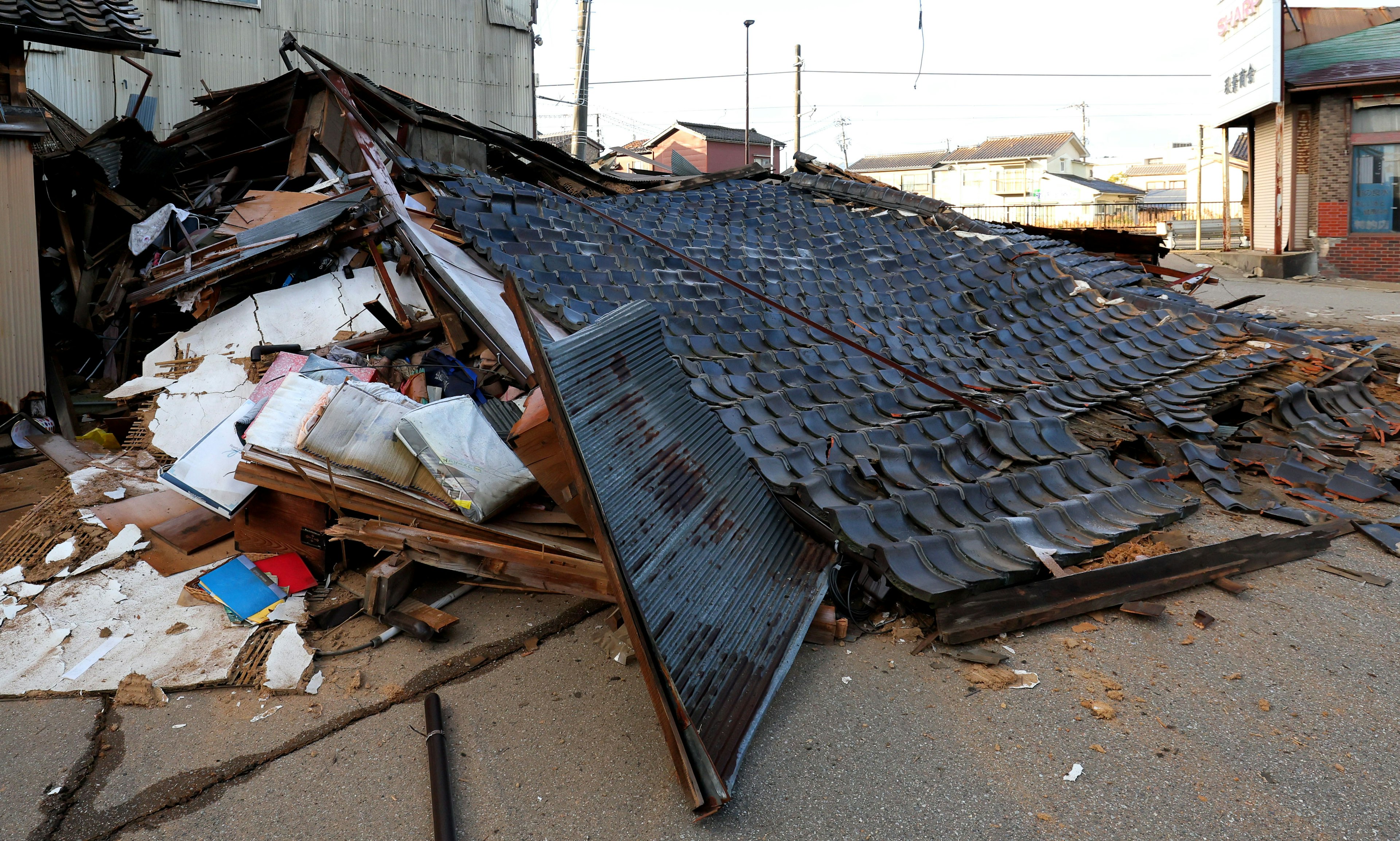 Gambar puing-puing bangunan yang runtuh dengan sampah berserakan