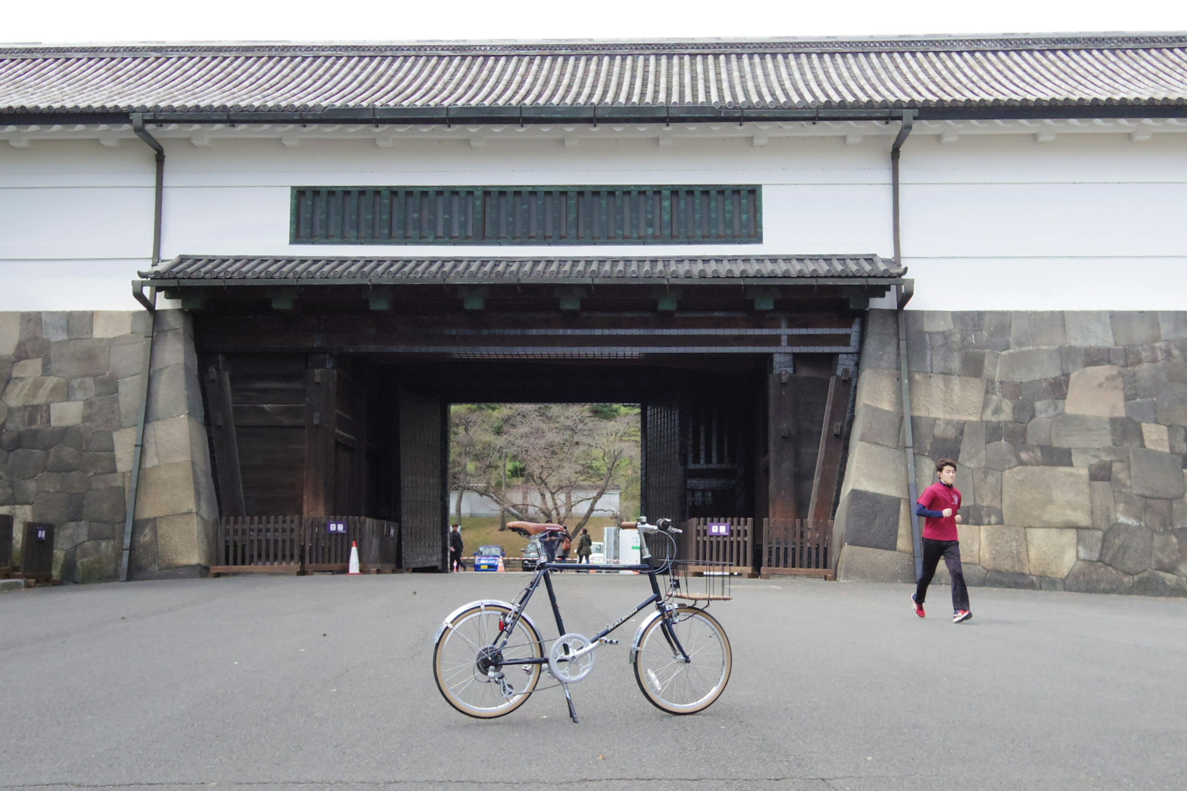 城門の前に自転車が置かれた風景 人が通り過ぎる