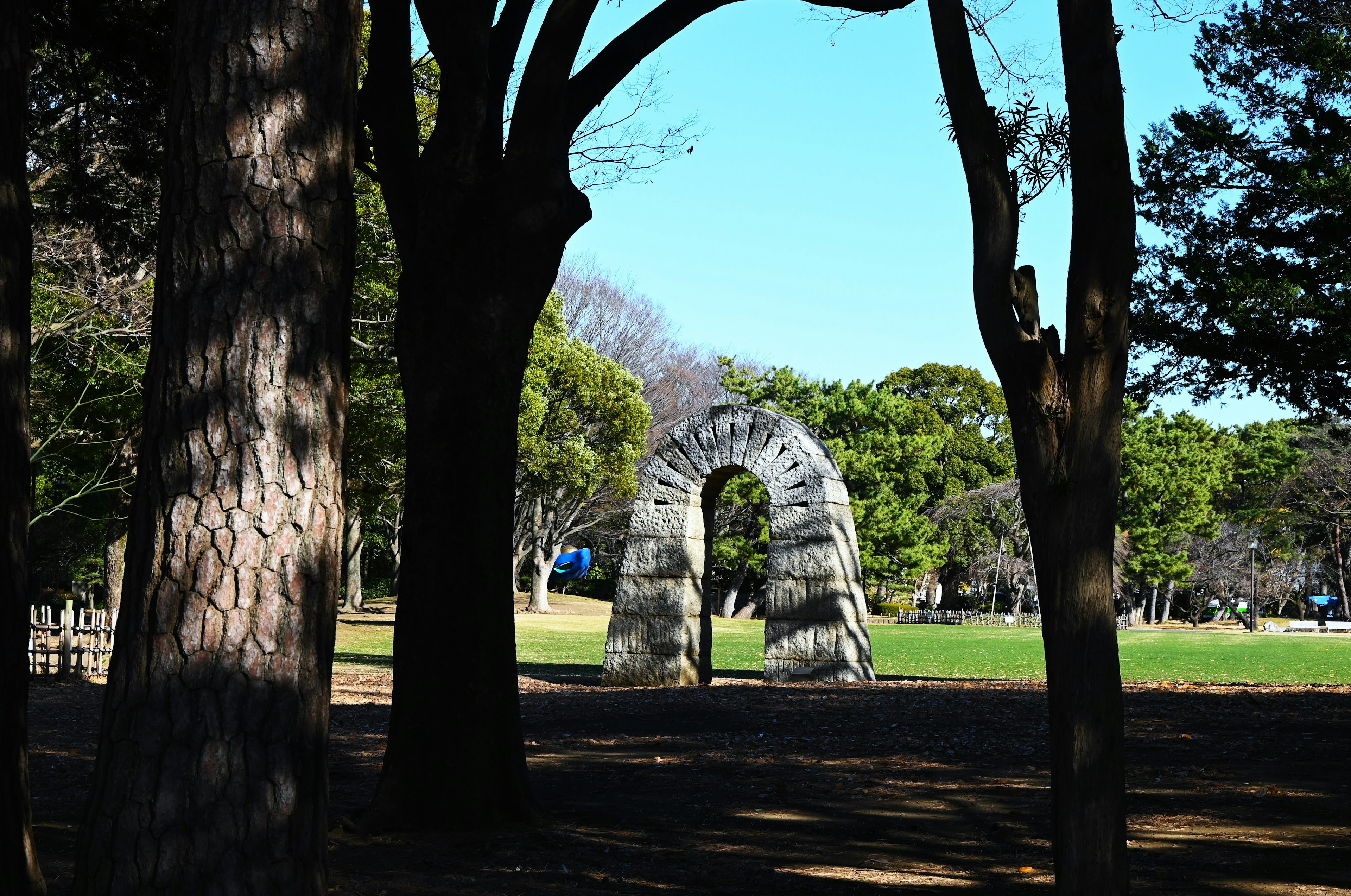 公園内の石のアーチと周囲の木々