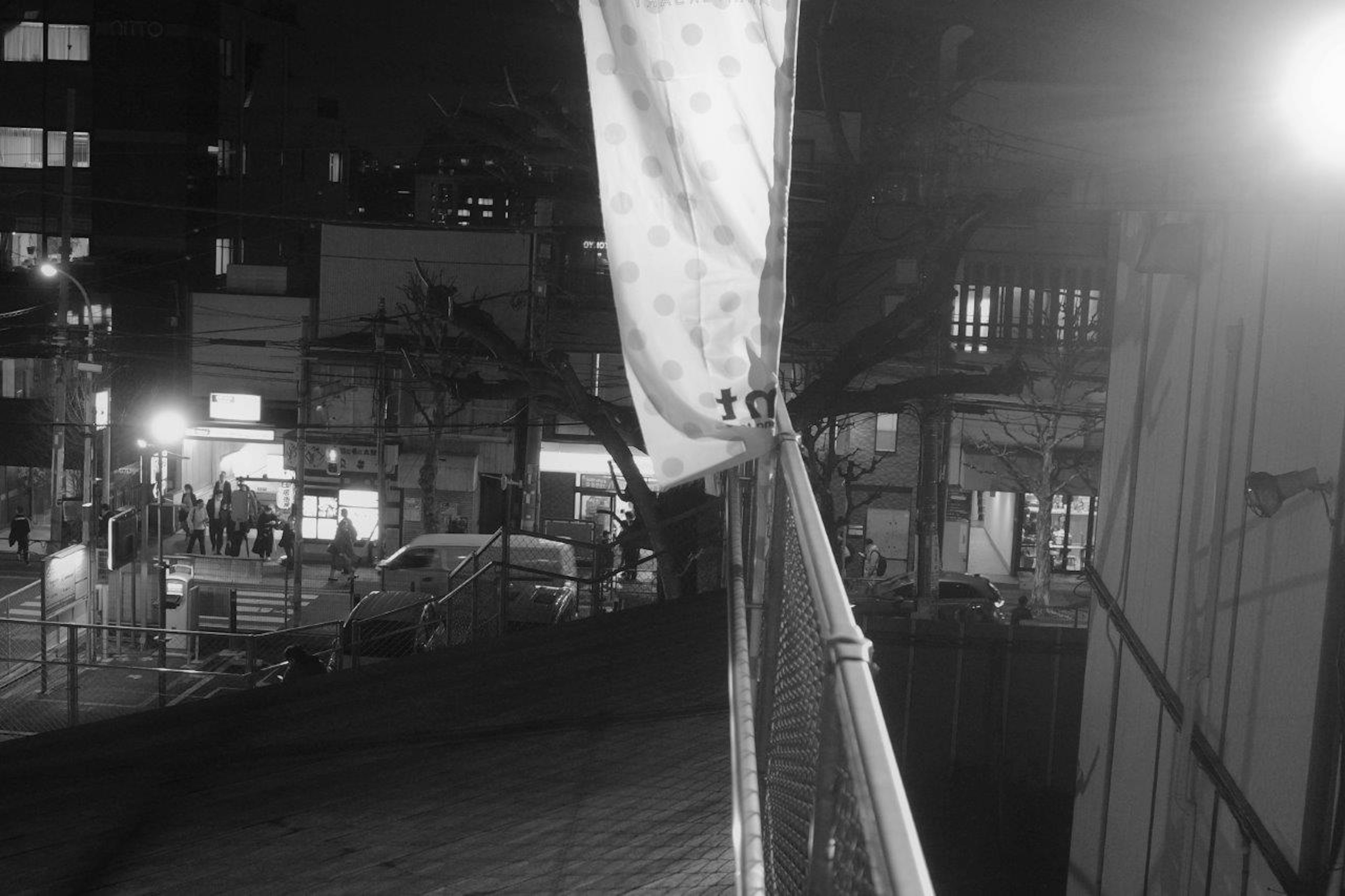 Un tejido blanco ondeando al viento con un fondo de ciudad nocturna