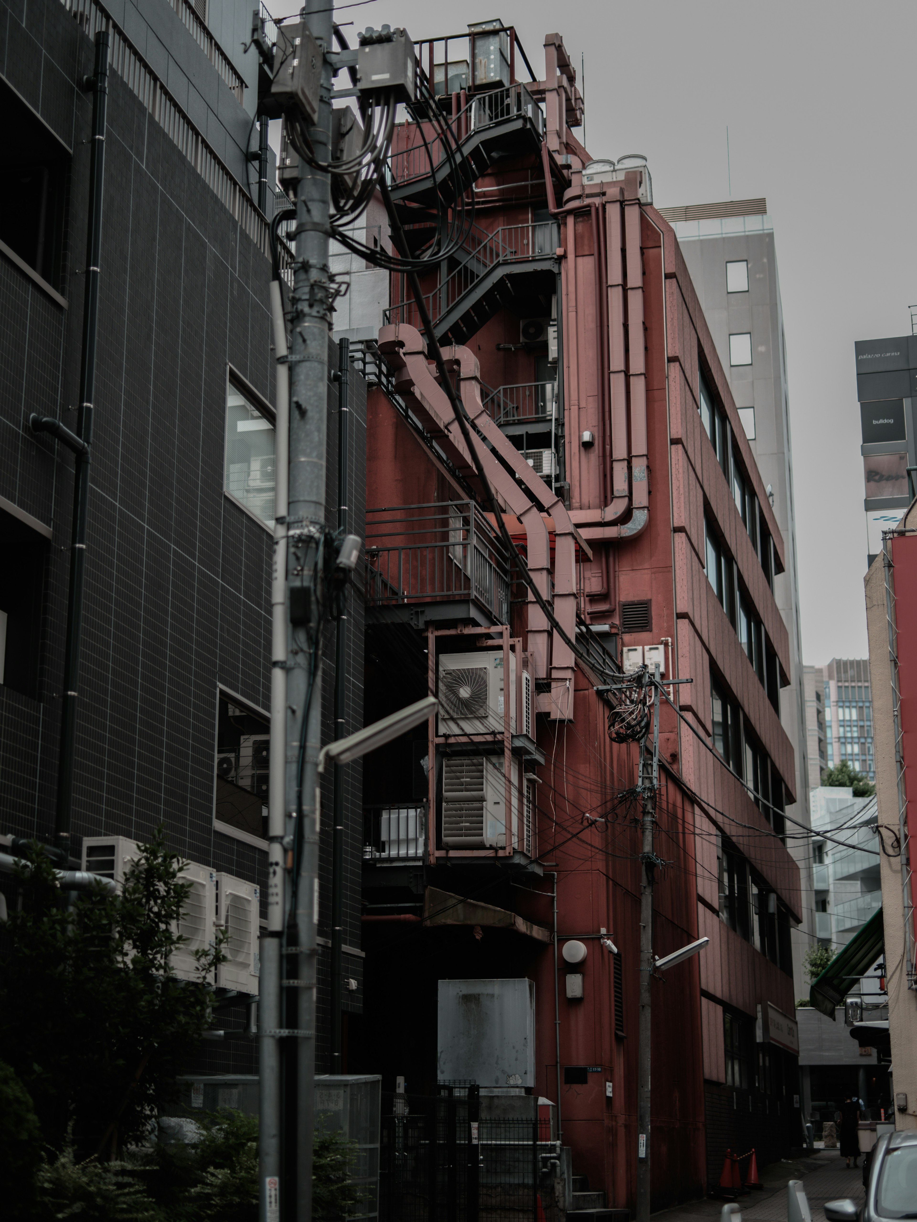 Escena urbana con un edificio rojo y postes eléctricos