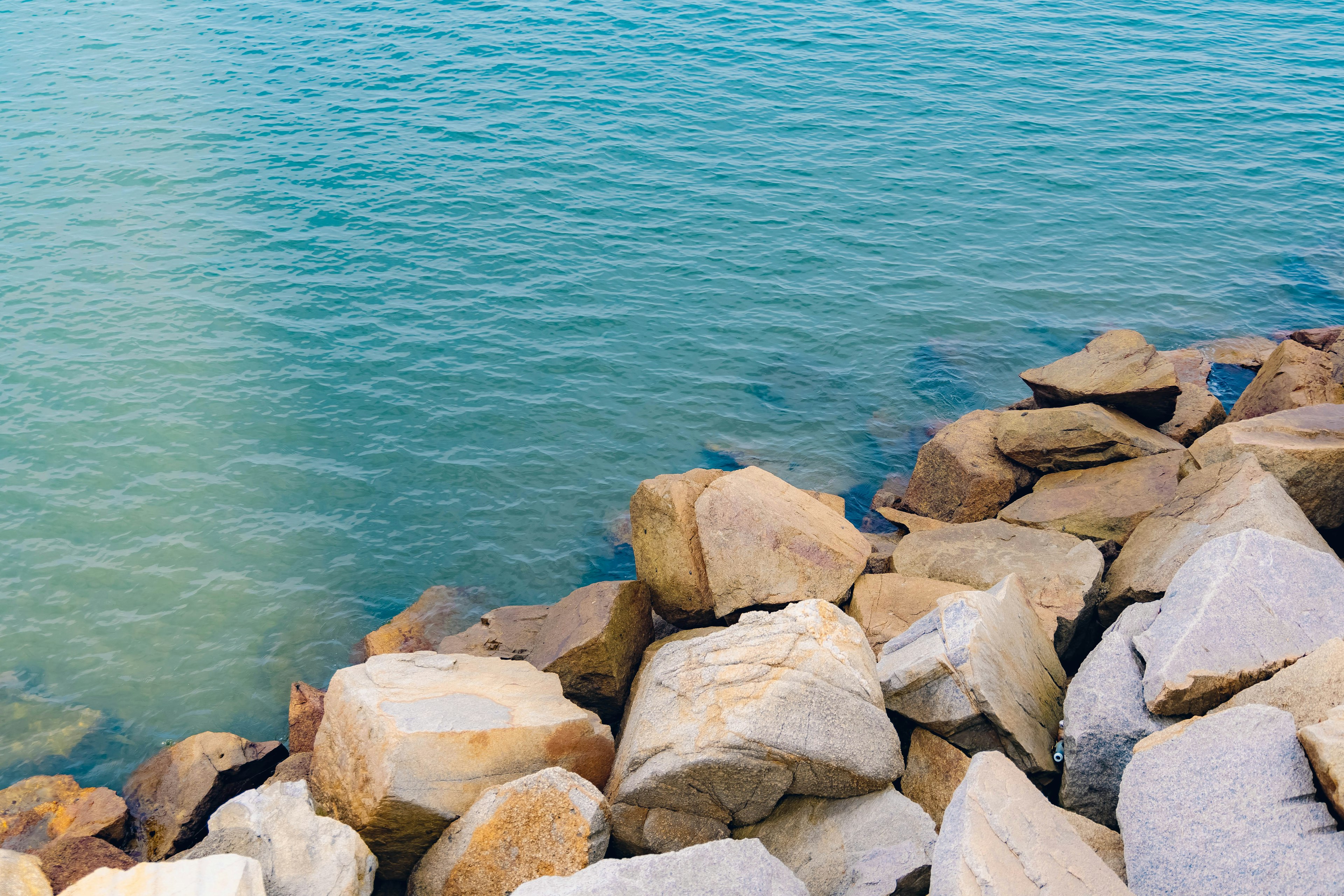 Küstenansicht mit klarem blauen Wasser und felsigem Ufer