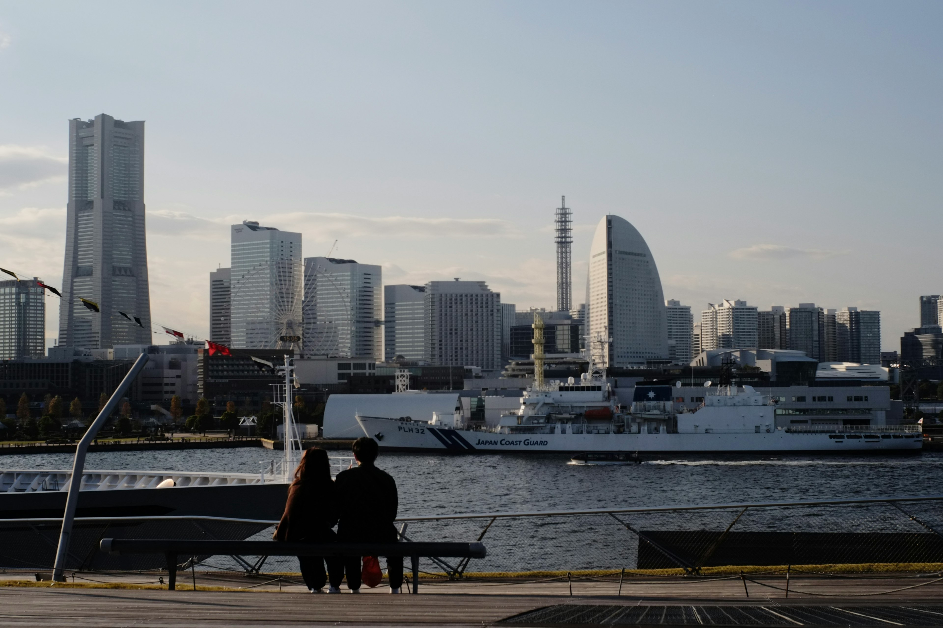 横浜の海を背景にしたカップルと近代的なビル群