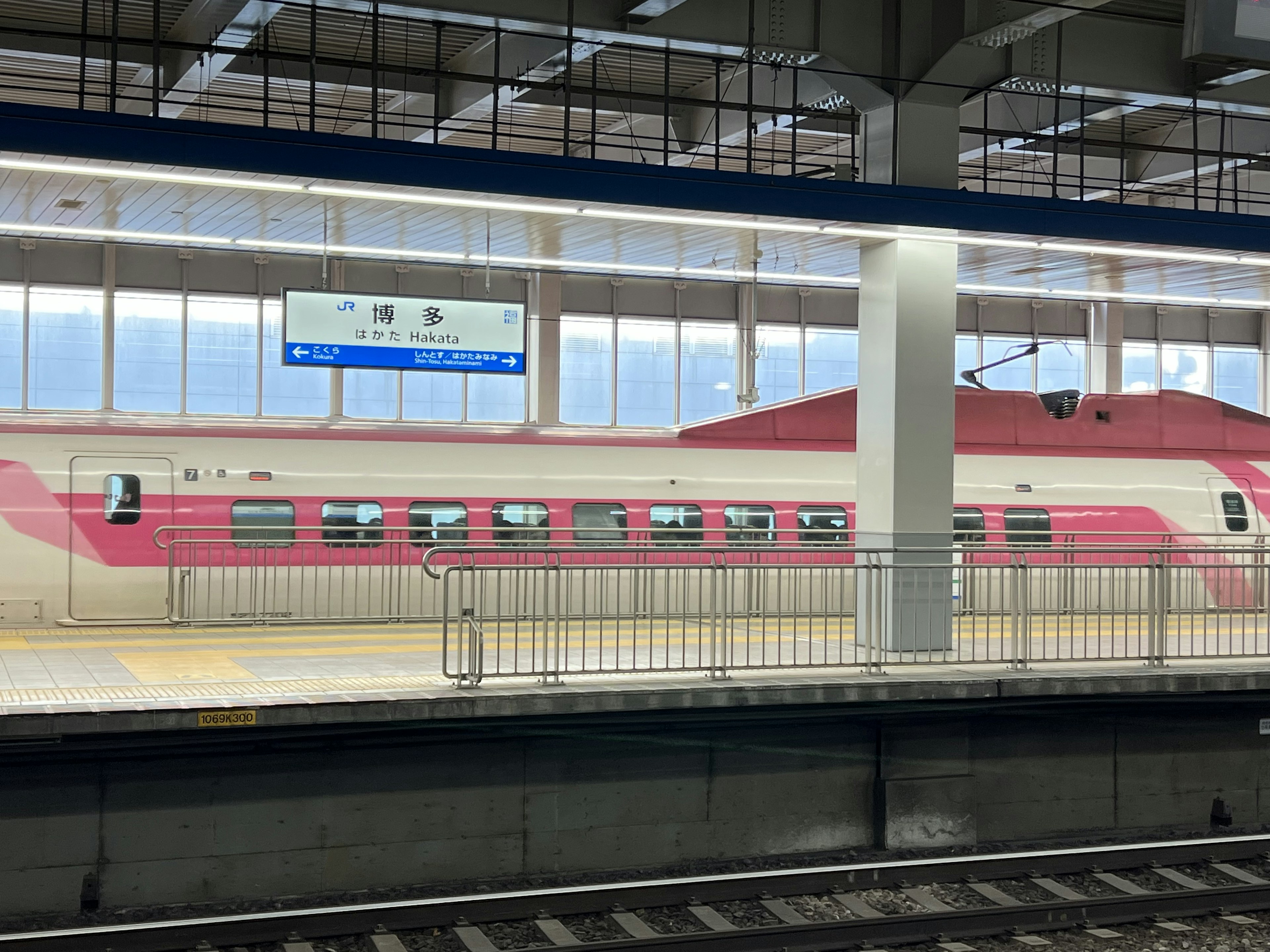 Kereta Shinkansen merah muda di stasiun kereta modern