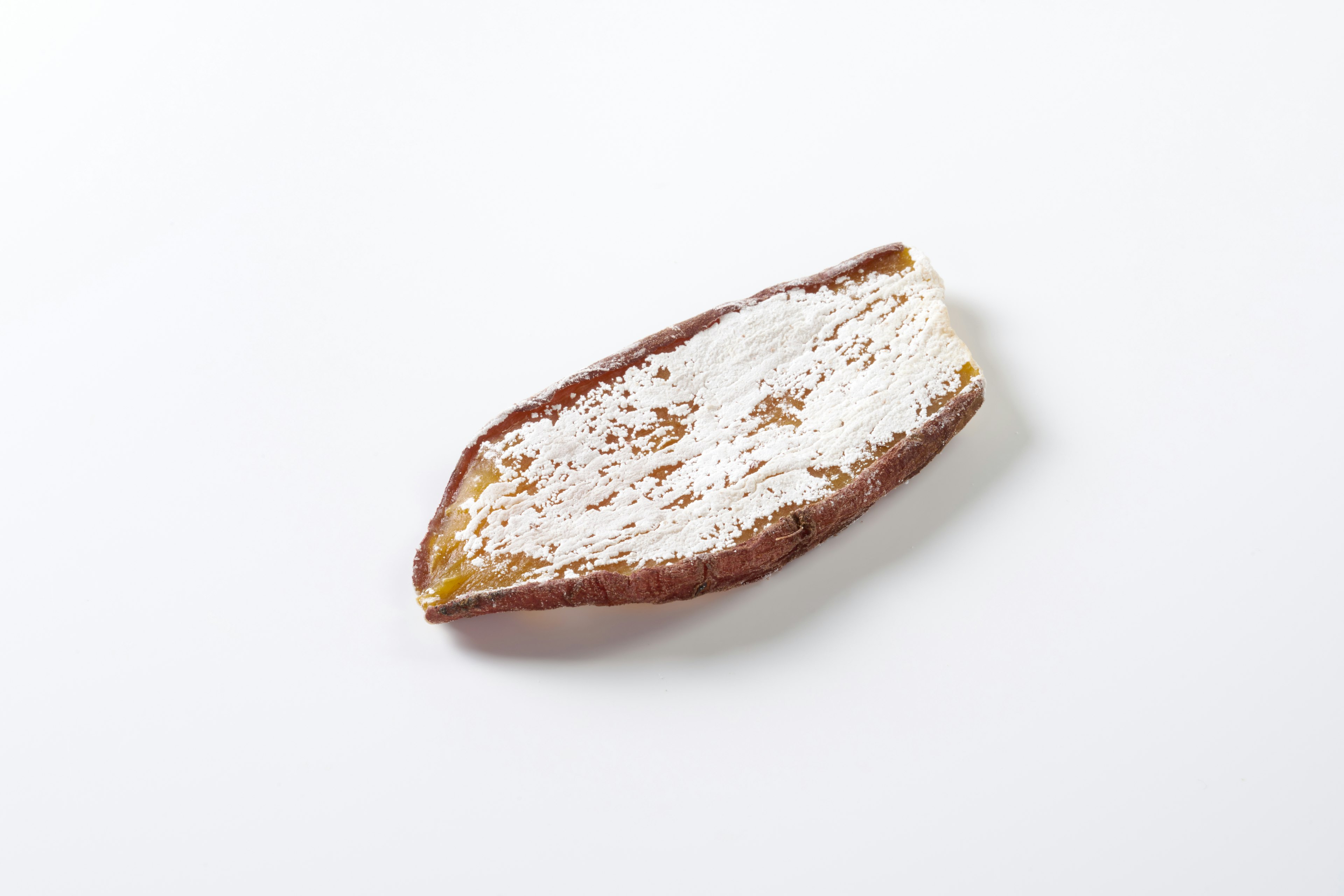 A thin brown slice of dried fruit on a white background