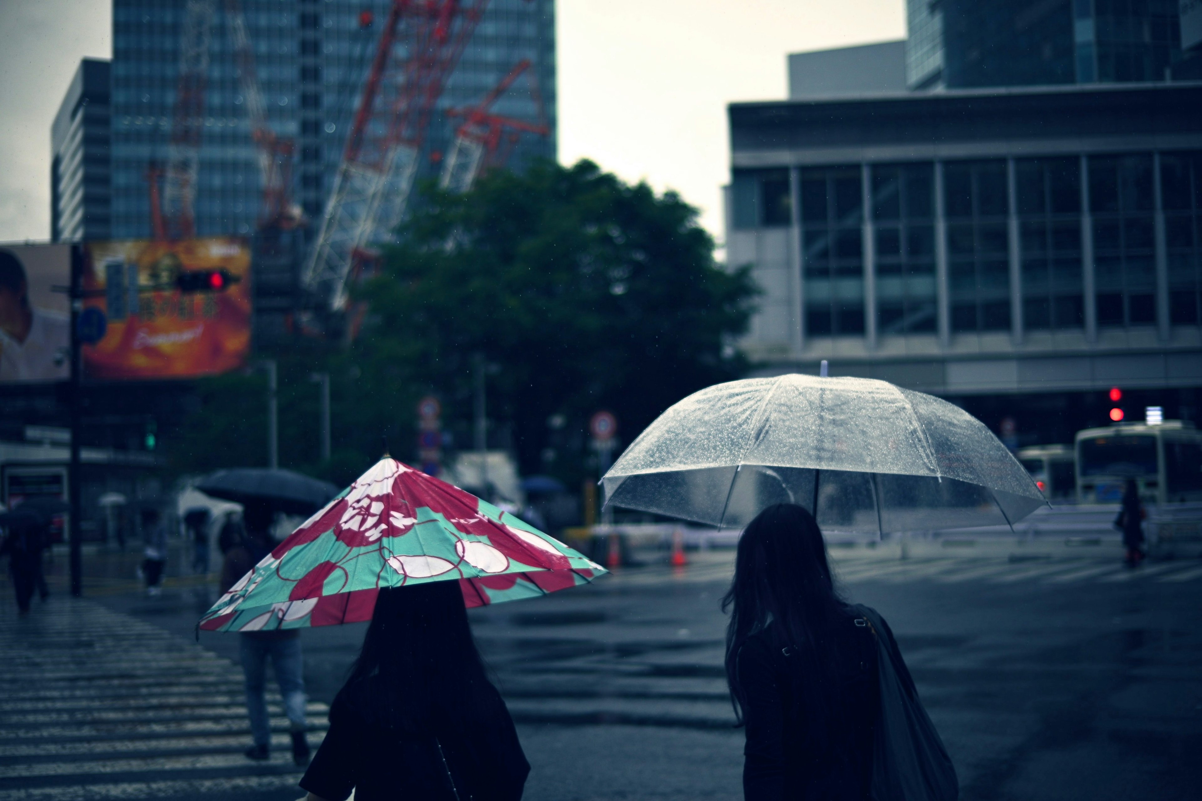 Deux femmes marchant avec des parapluies dans un paysage urbain