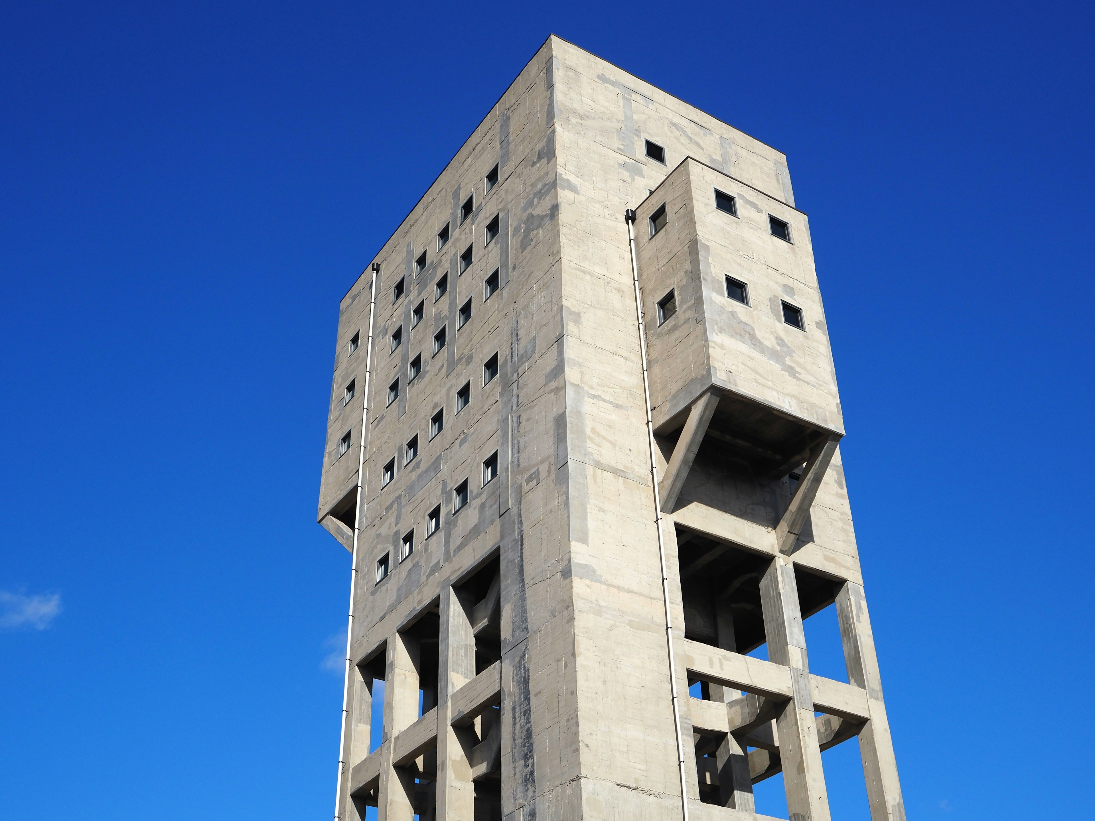 Nahaufnahme eines Betonturms unter einem blauen Himmel