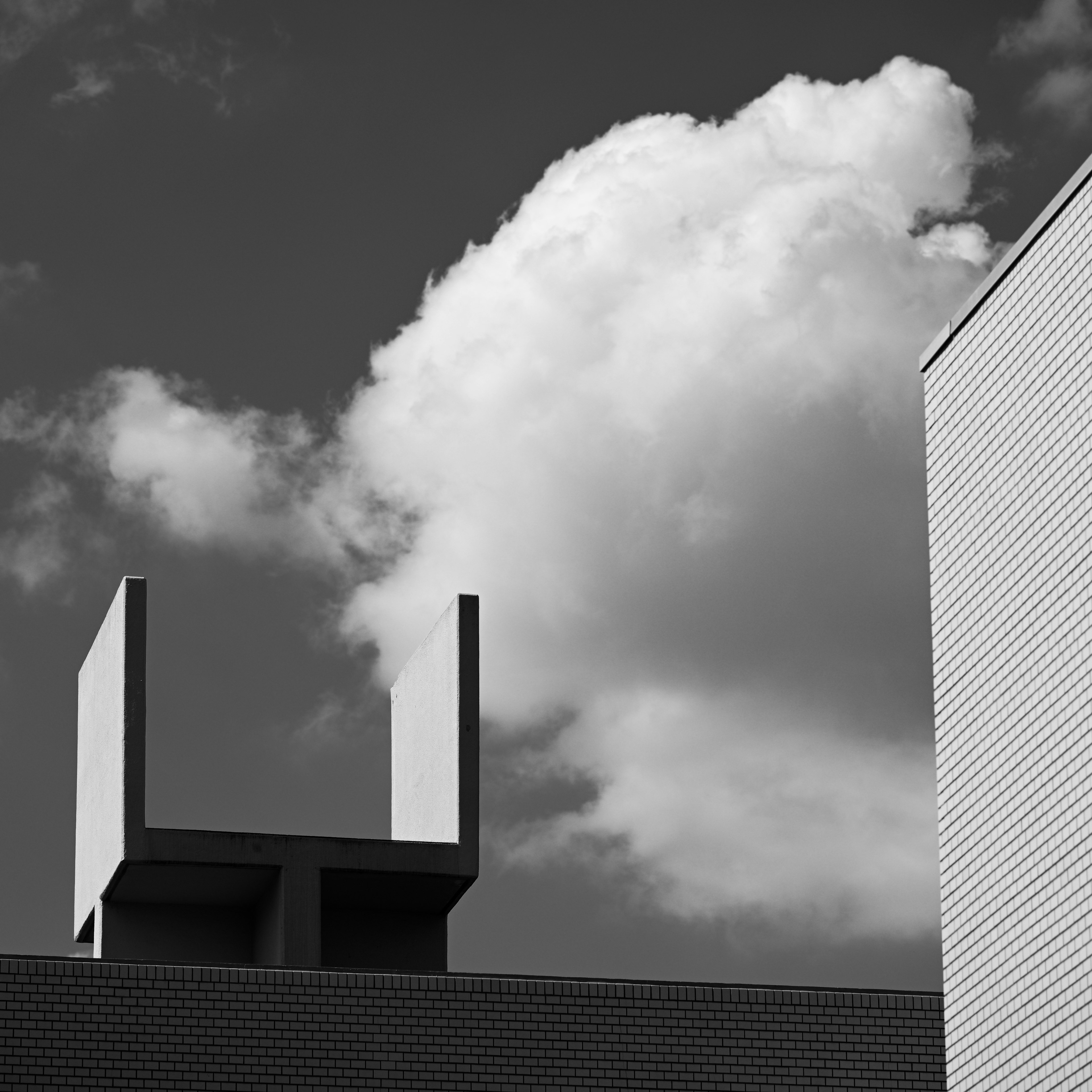 Moderne Architektur mit Wolkenkontrast Fotografie in Schwarzweiß