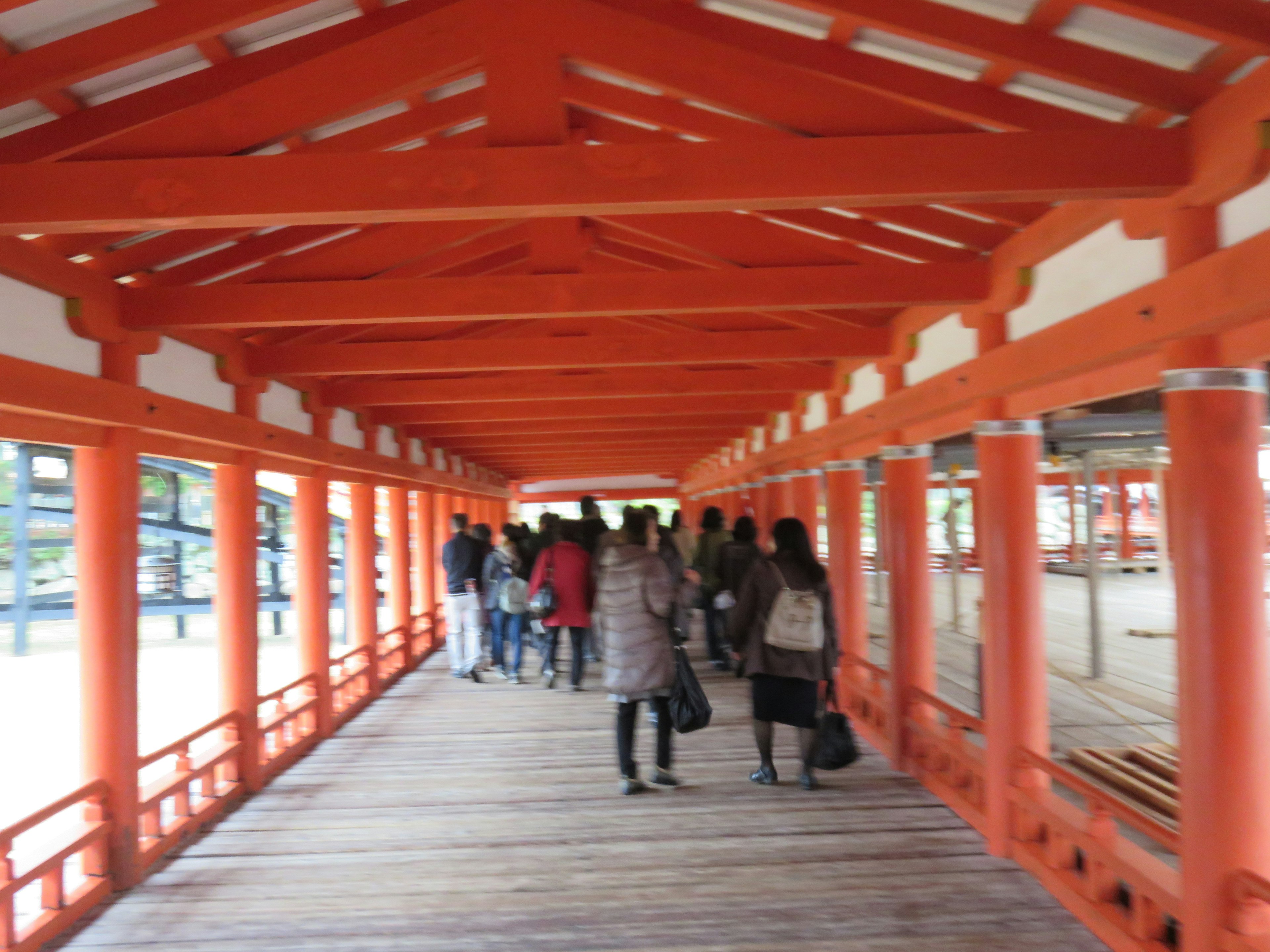 Persone che camminano su un corridoio di ponte arancione