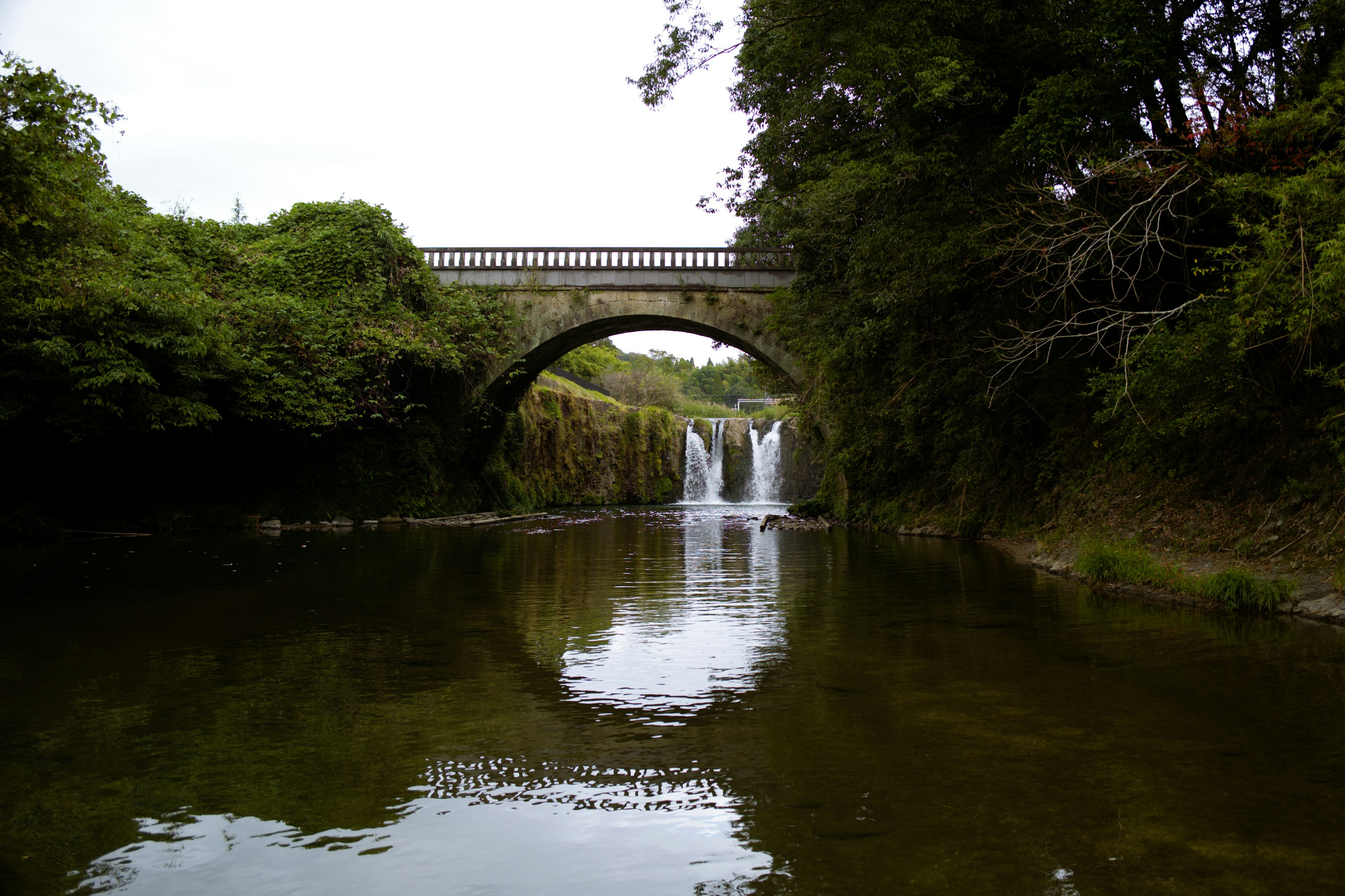 Serene river landscape featuring a bridge and waterfalls