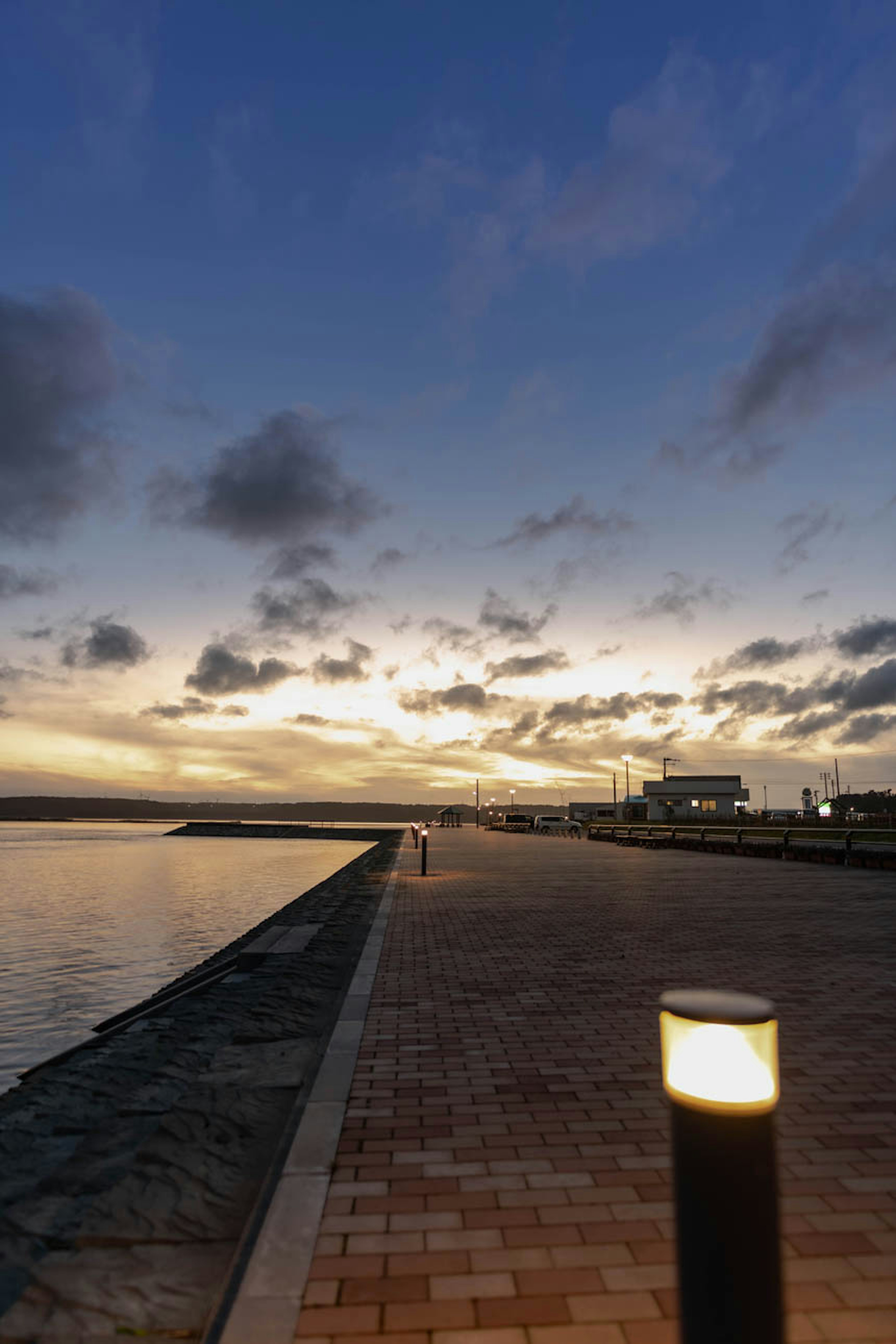 Coastal walkway at dusk with a lamppost