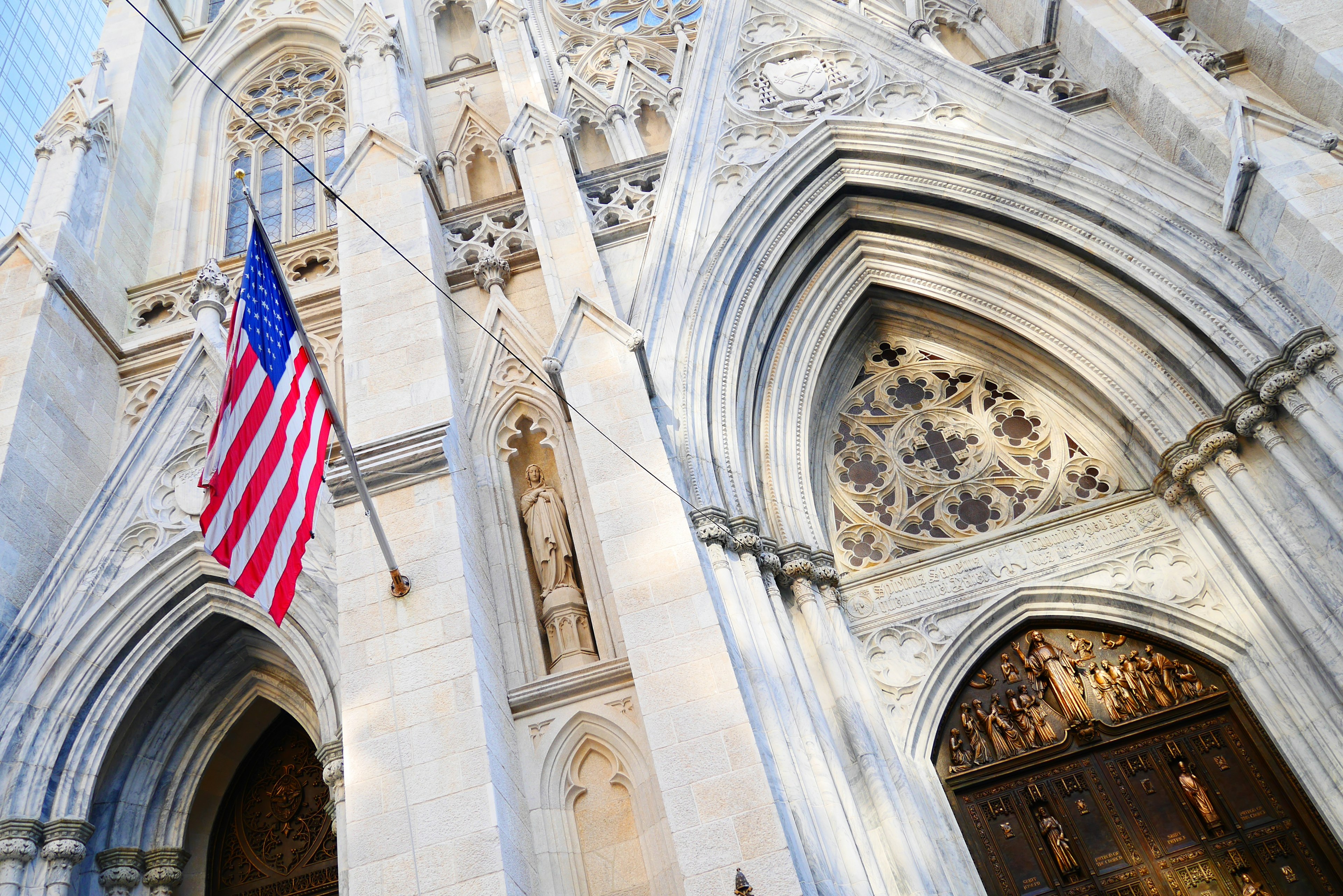 Gothische Kirchenfassade mit amerikanischer Flagge und kunstvollen Schnitzereien