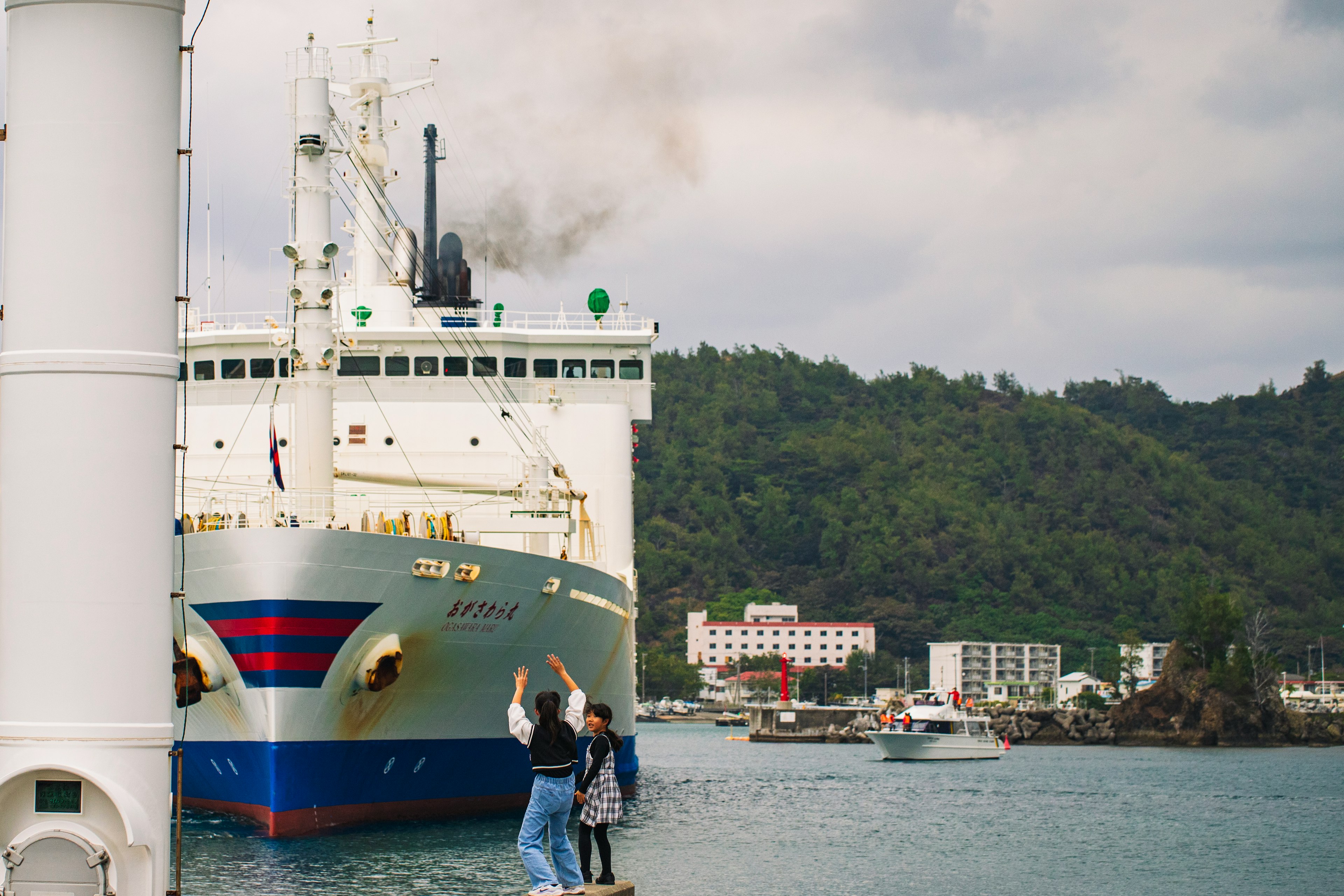 Großes Schiff im Hafen mit zwei Personen, die vorne winken