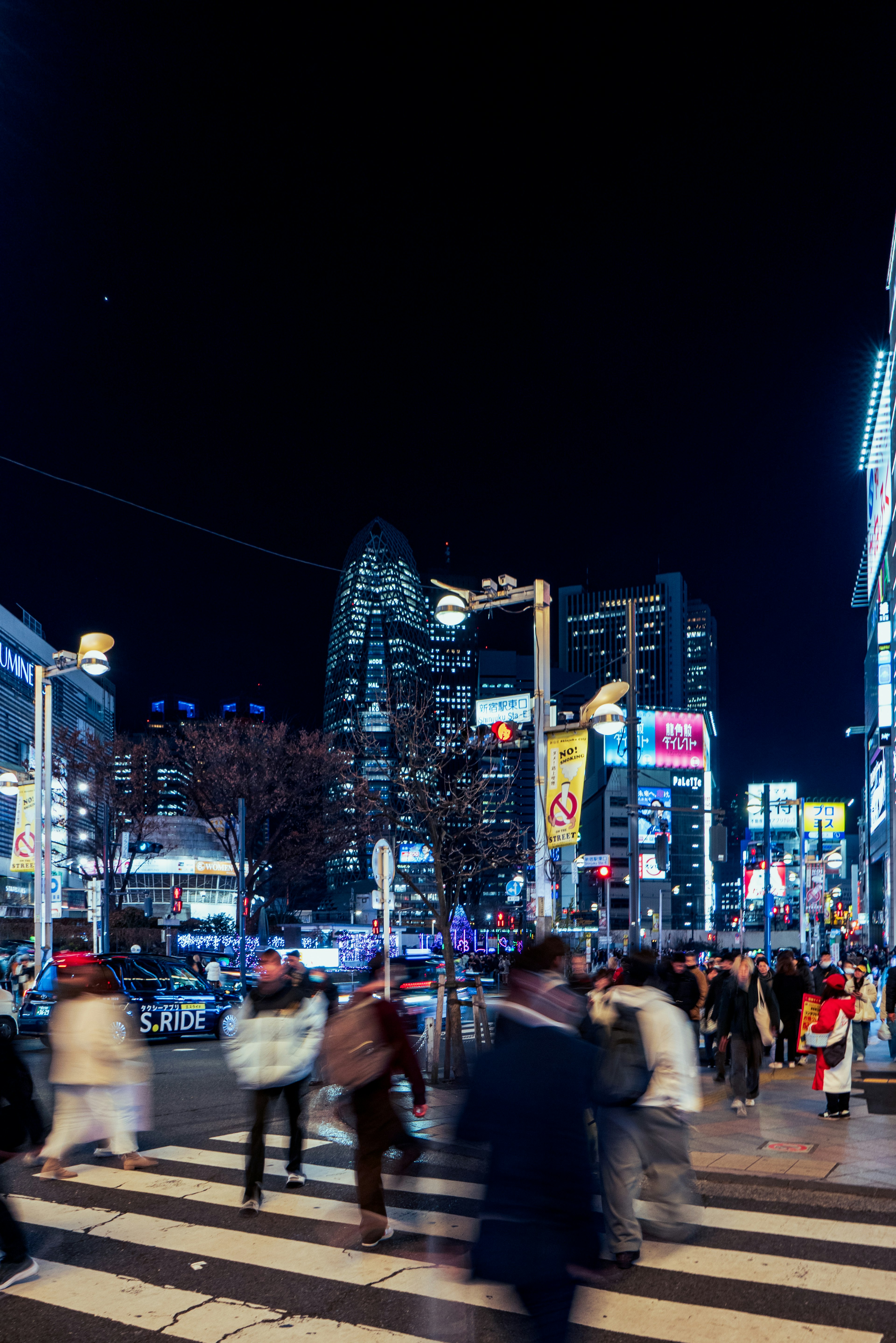 夜间城市风景，有人过马路和明亮的广告牌