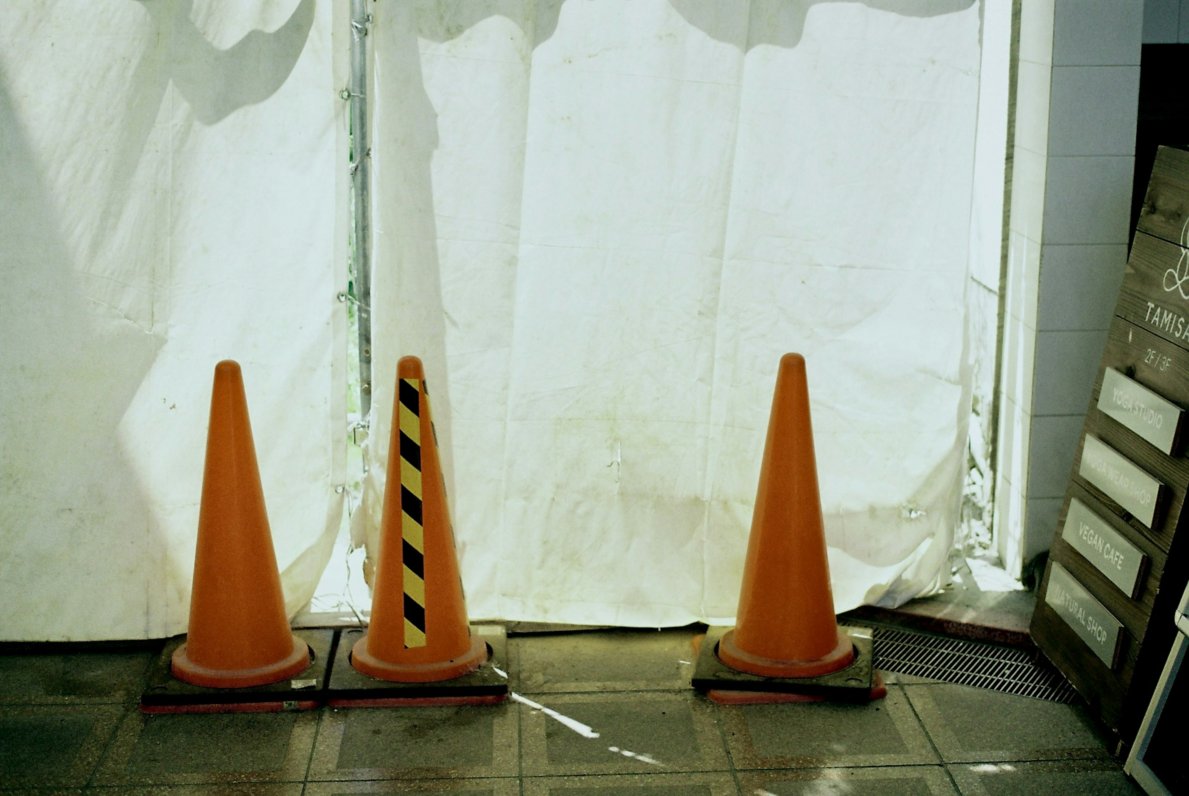 Trois cônes de circulation orange alignés à l'entrée d'un chantier