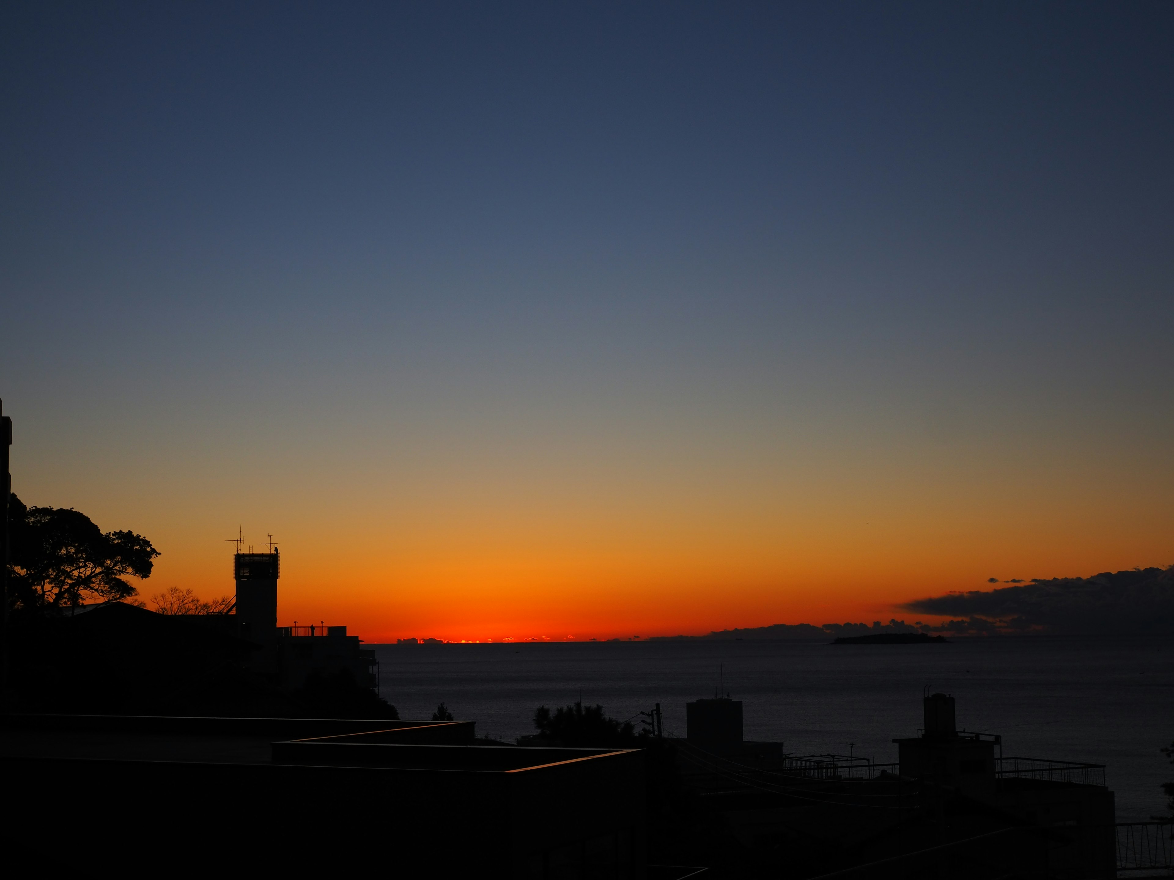 夕日が海に沈む美しい風景とシルエットの建物