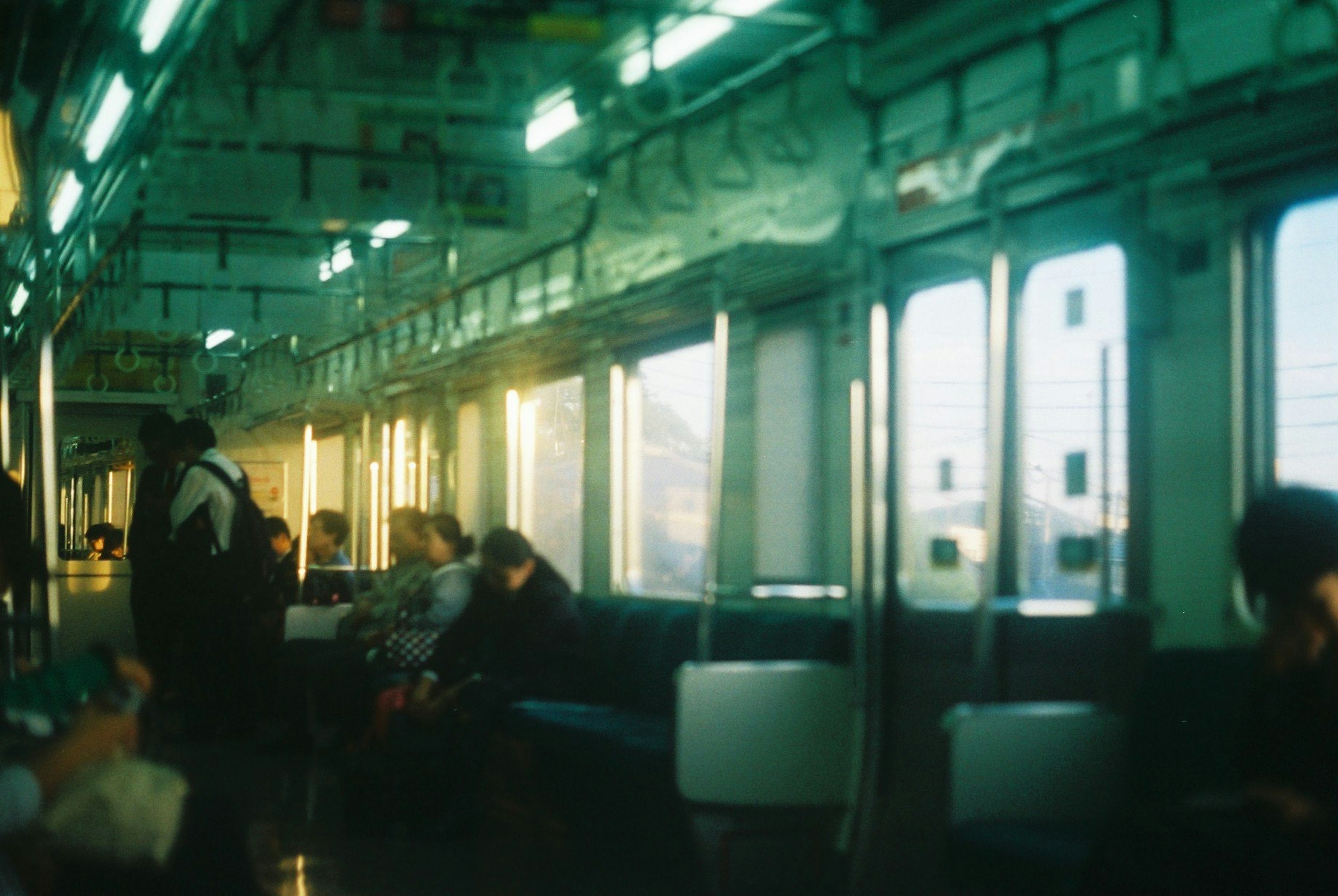 Intérieur d'un wagon de train avec des passagers assis et la lumière du soleil filtrant par les fenêtres