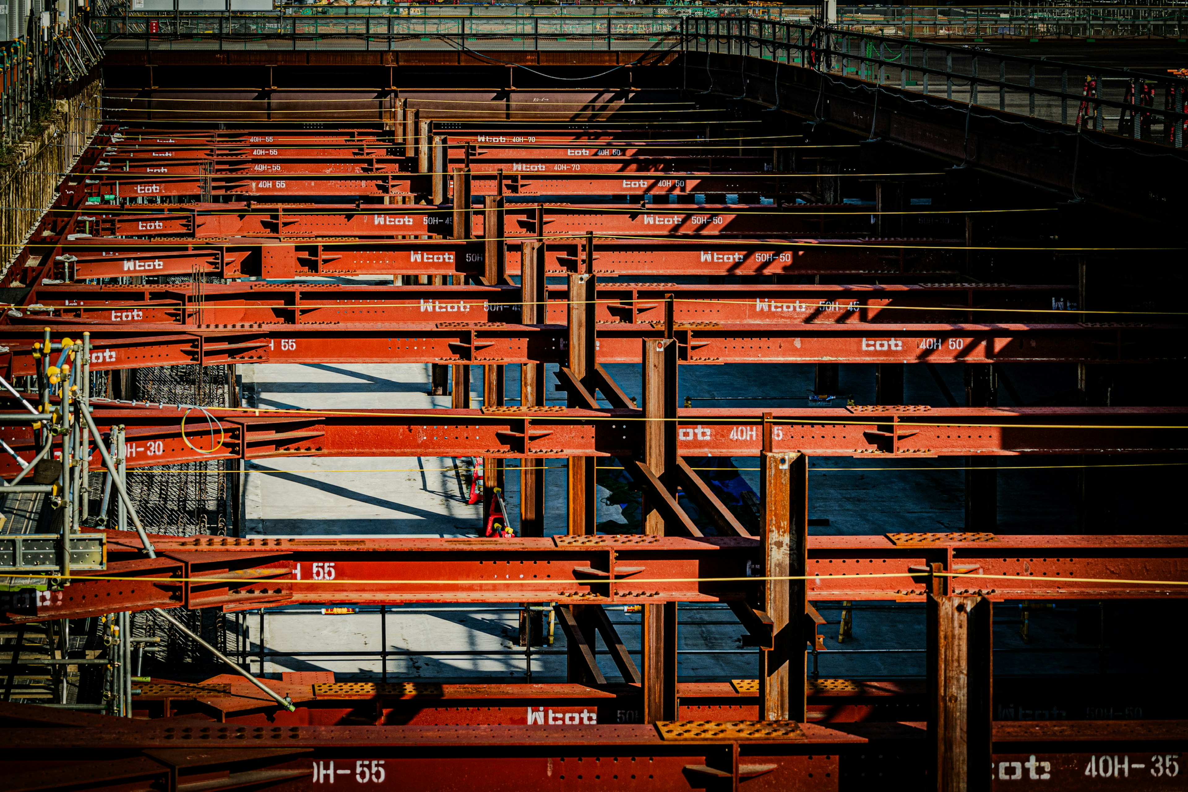 Image d'un chantier avec des poutres en acier rouges et des structures