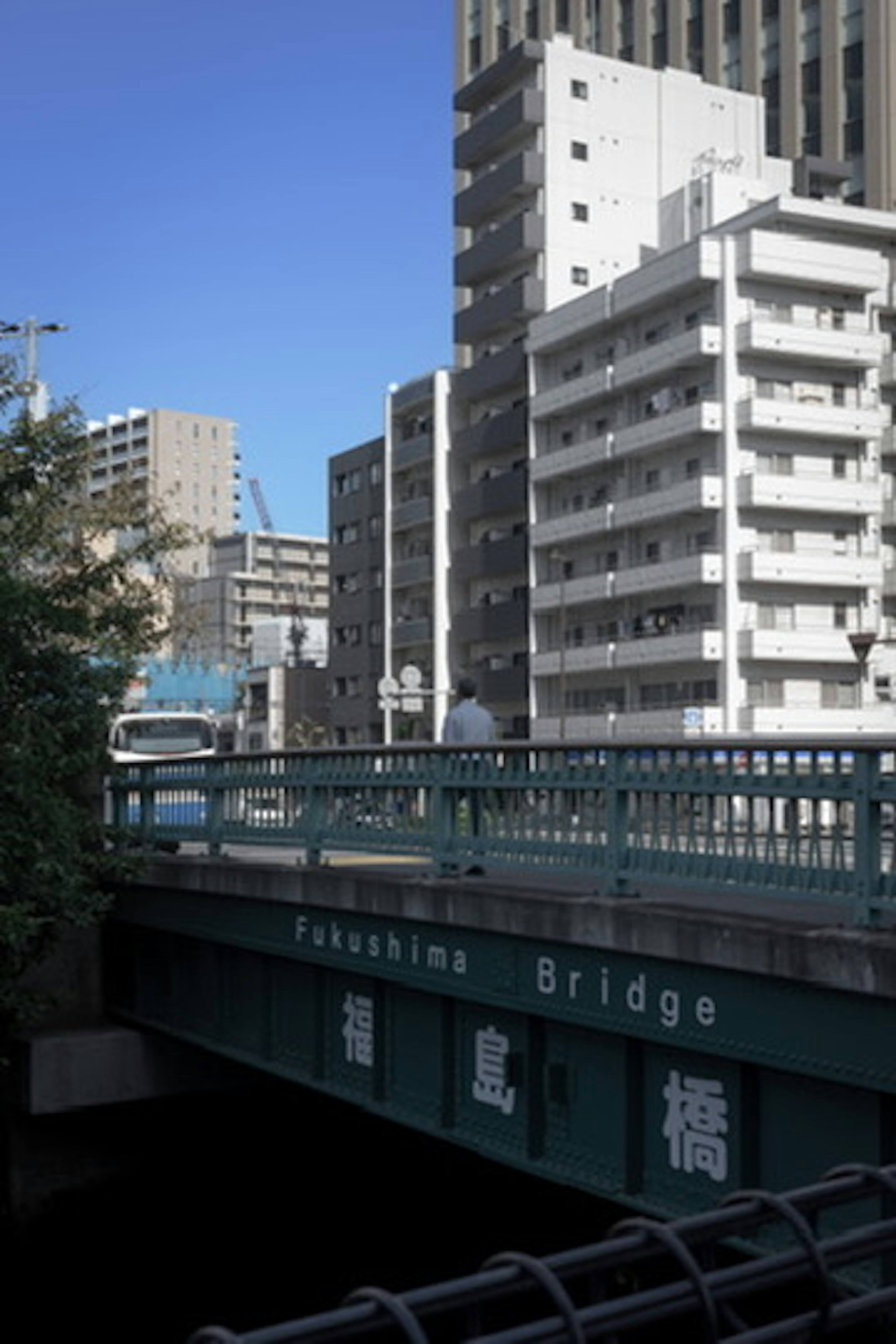 ペダル橋の上に立つ人物と高層ビルの景色