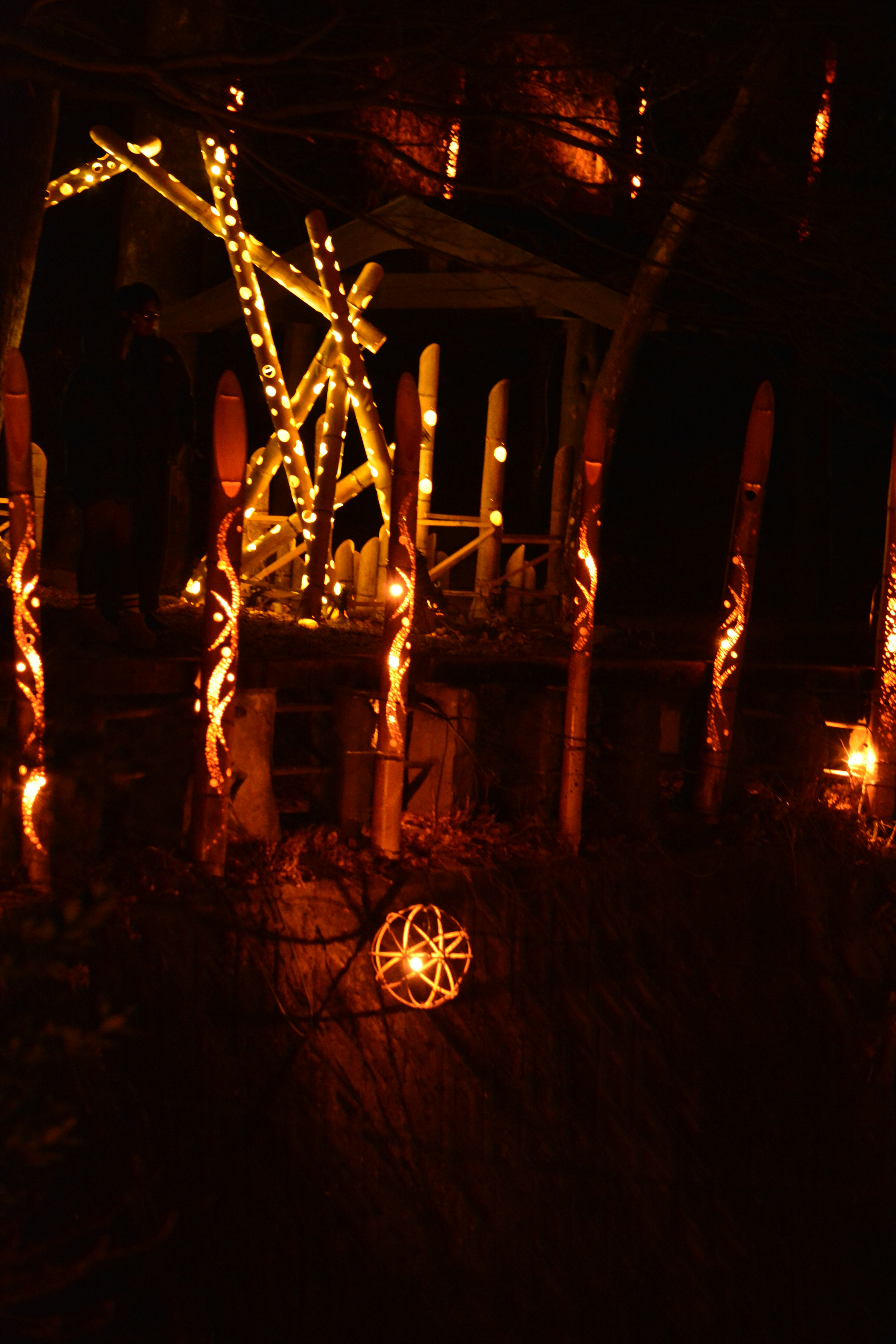 Scène nocturne avec des décorations en bois et des sculptures illuminées par des lumières