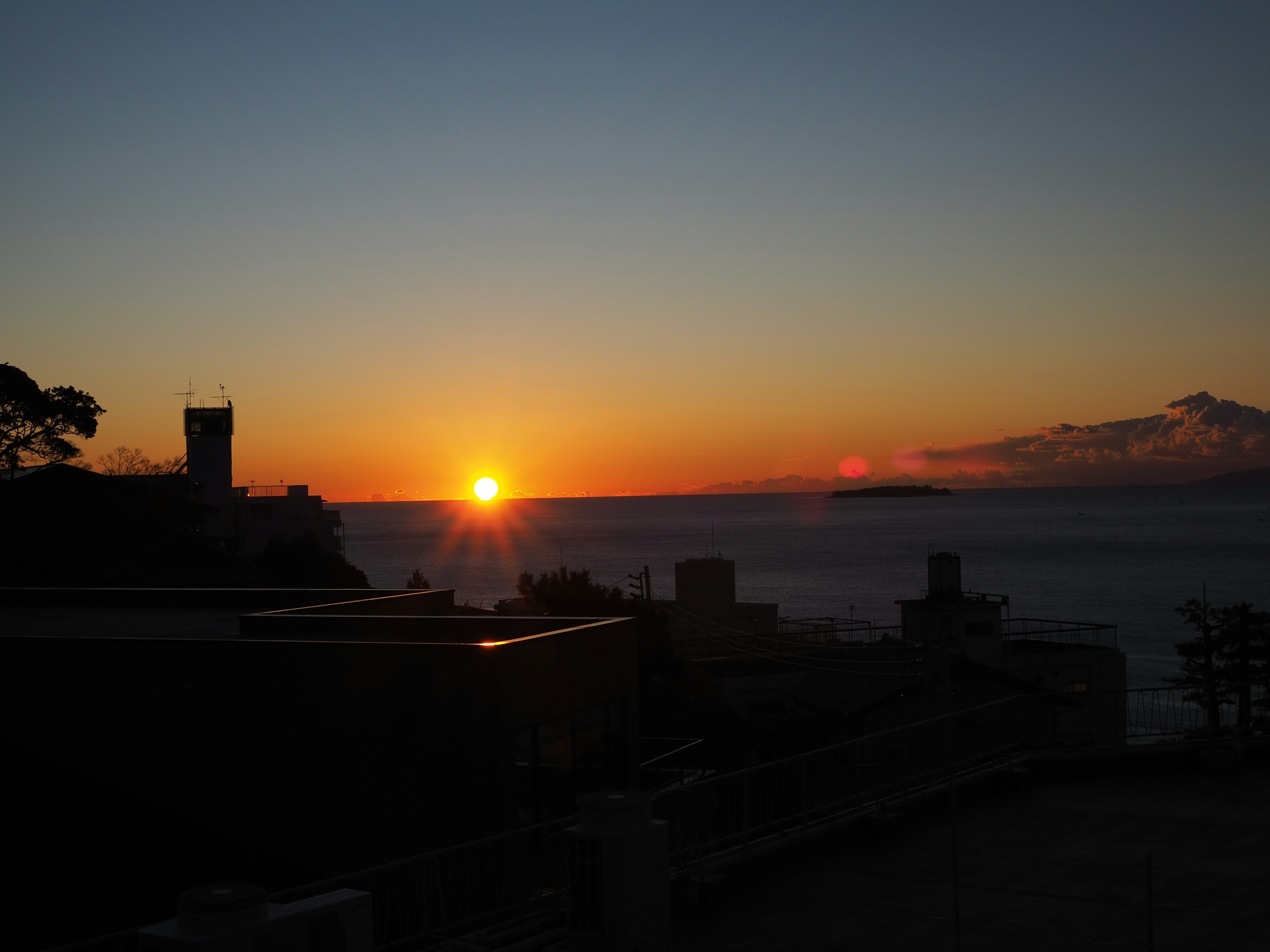 Tramonto sul mare con silhouette di edifici