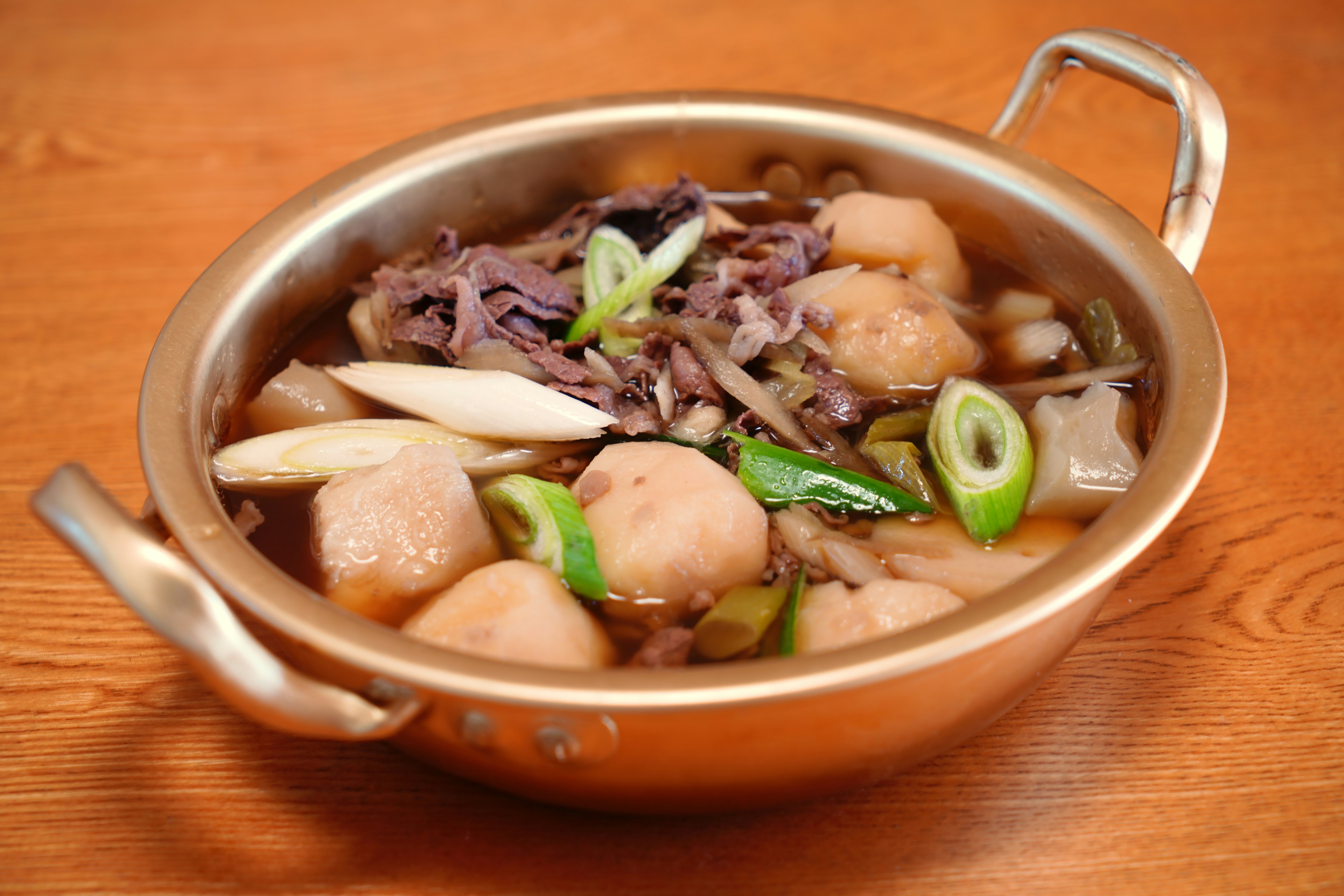 Sebuah panci berisi bakso dan sayuran dalam kuah