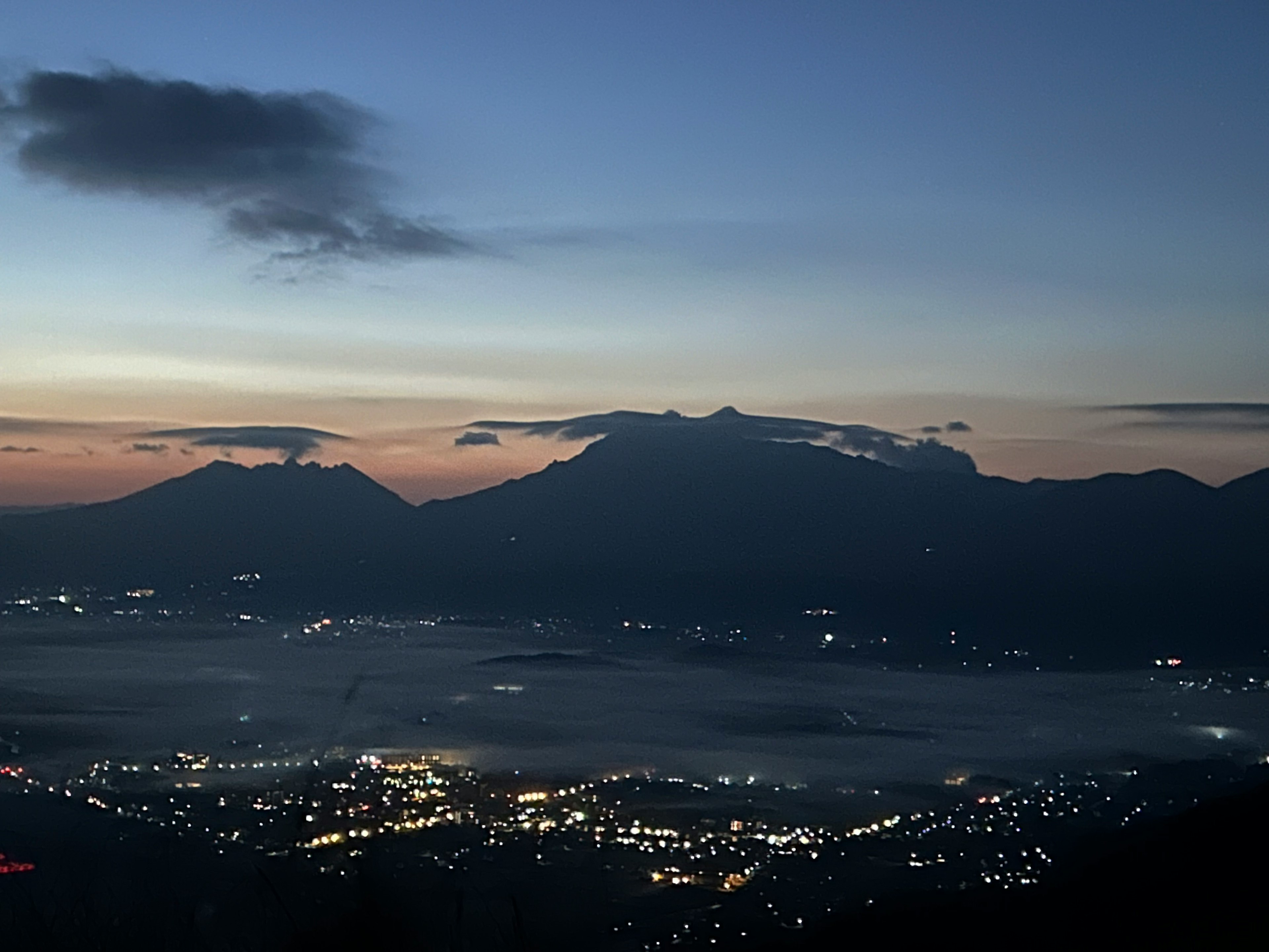 Vista del crepúsculo de las montañas y las luces de la ciudad