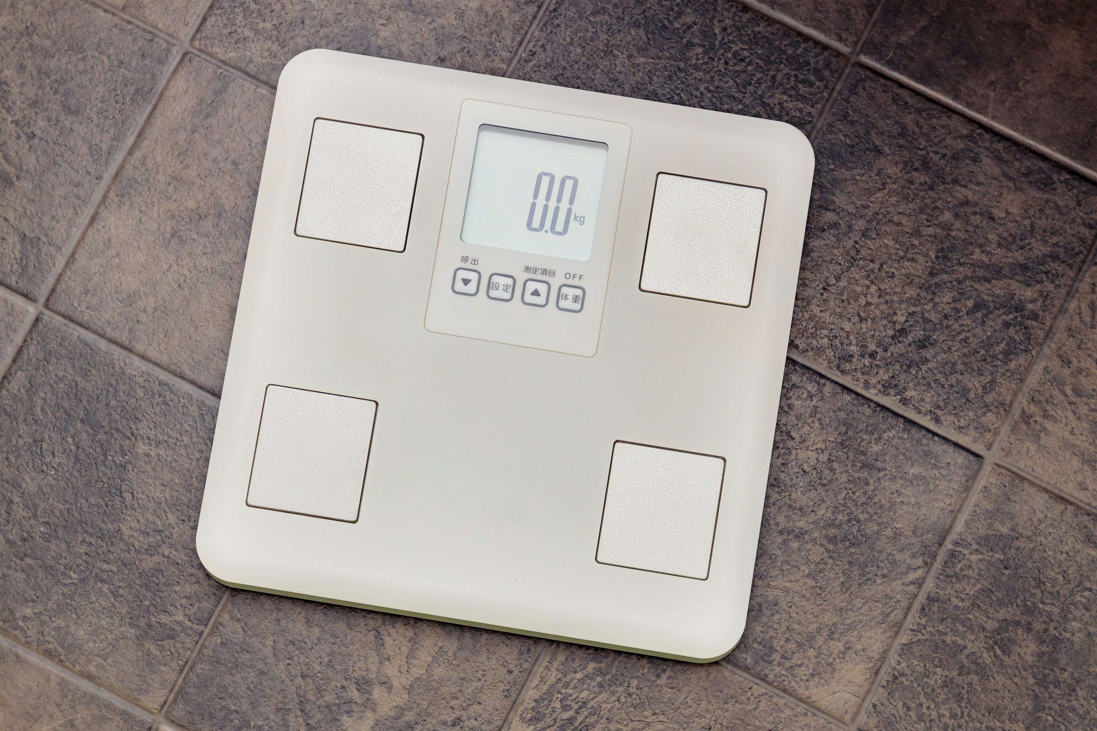 Digital weighing scale placed on tiled floor