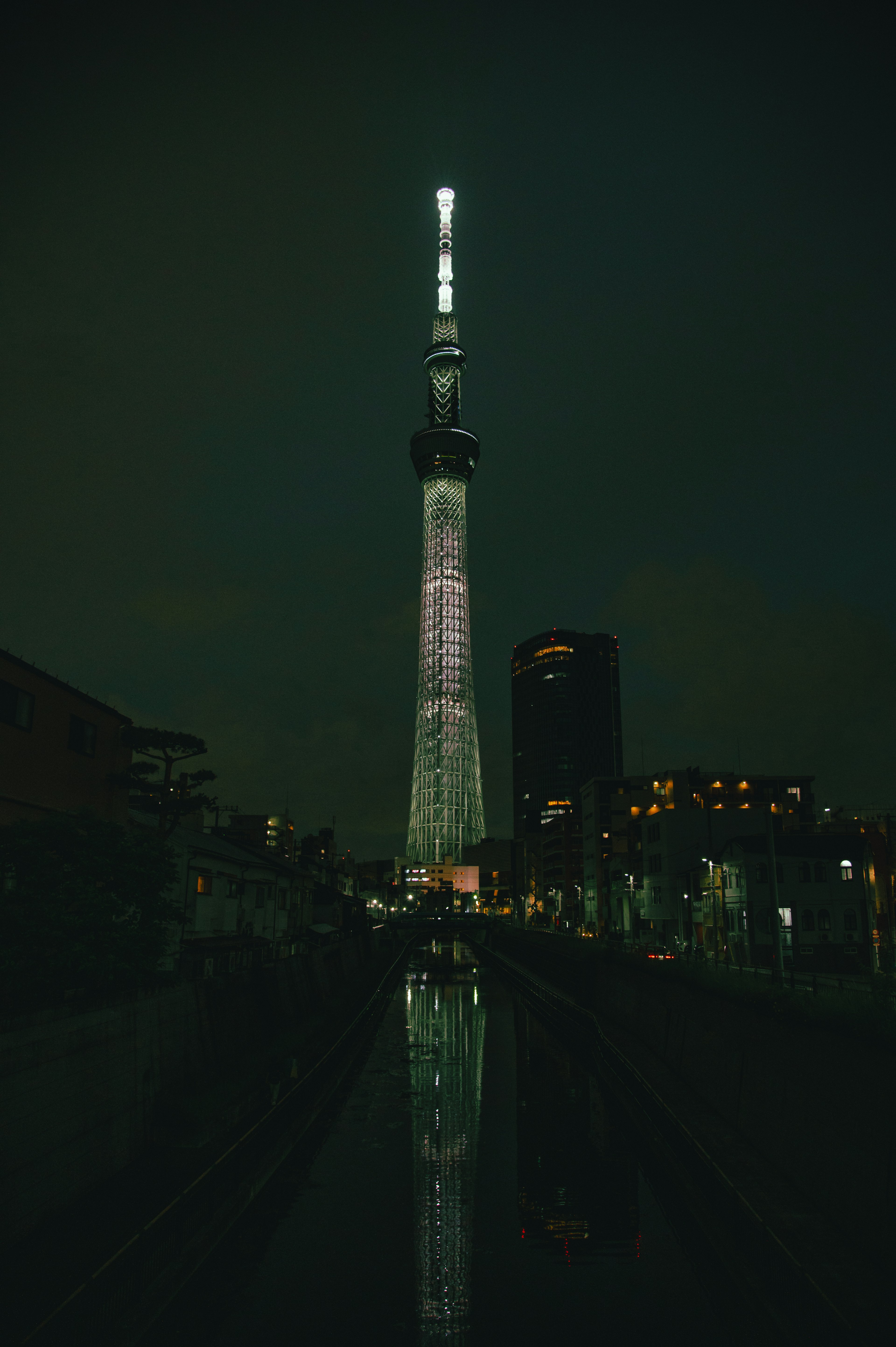 Tokyo Skytree yang diterangi di malam hari dengan pantulan di air