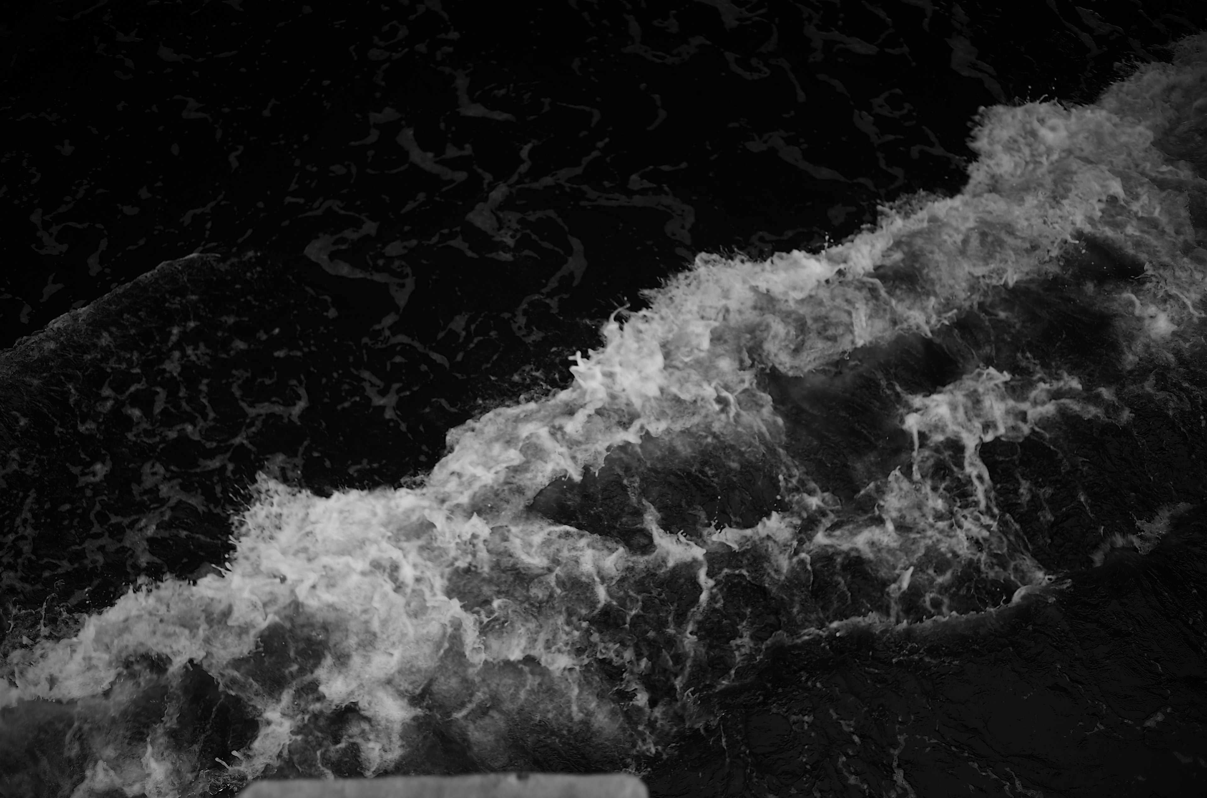 White waves crashing against a dark background